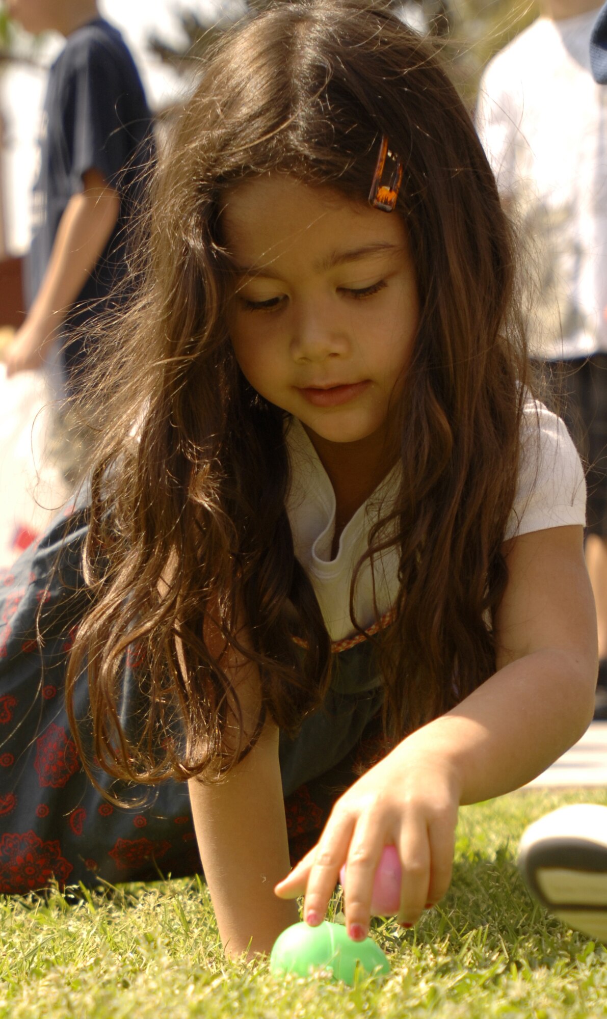 Diana Price, daughter of Tech Sgt. William Price, 728th Air Mobility Squadron, picks up candy-filled eggs to stuff her basket during the annual spring egg hunt, Saturday, April 11, 2009 at Arkadas Park. Approximately 550 base residents participated in activities at the event, which included arts and crafts, photos with the Easter Bunny and egg hunts. Four different age groups participated in the egg hunts, which included 18 golden eggs. Golden eggs were turned in after the hunt for an Easter basket or a prize. (U.S. Air Force photo/Senior Airman Benjamin Wilson)