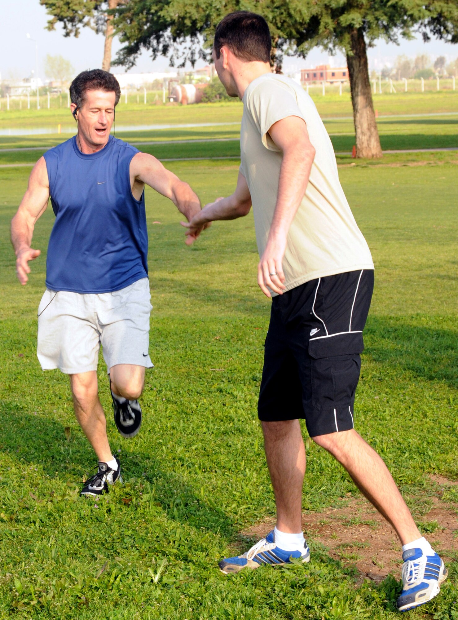 Scott Moore tags 2nd Lt. Frank Boyce, both from Team Random, for the start of the second leg of the Sexual Assault Awareness Month cross country relay race Saturday, April 11, 2009, at the Hodja Lakes Golf Course. The relay was a way to enjoy the Incirlik scenery and get information about the Sexual Assault Prevention and Response program. (U.S. Air Force photo/Senior Airman Heather Stanton)