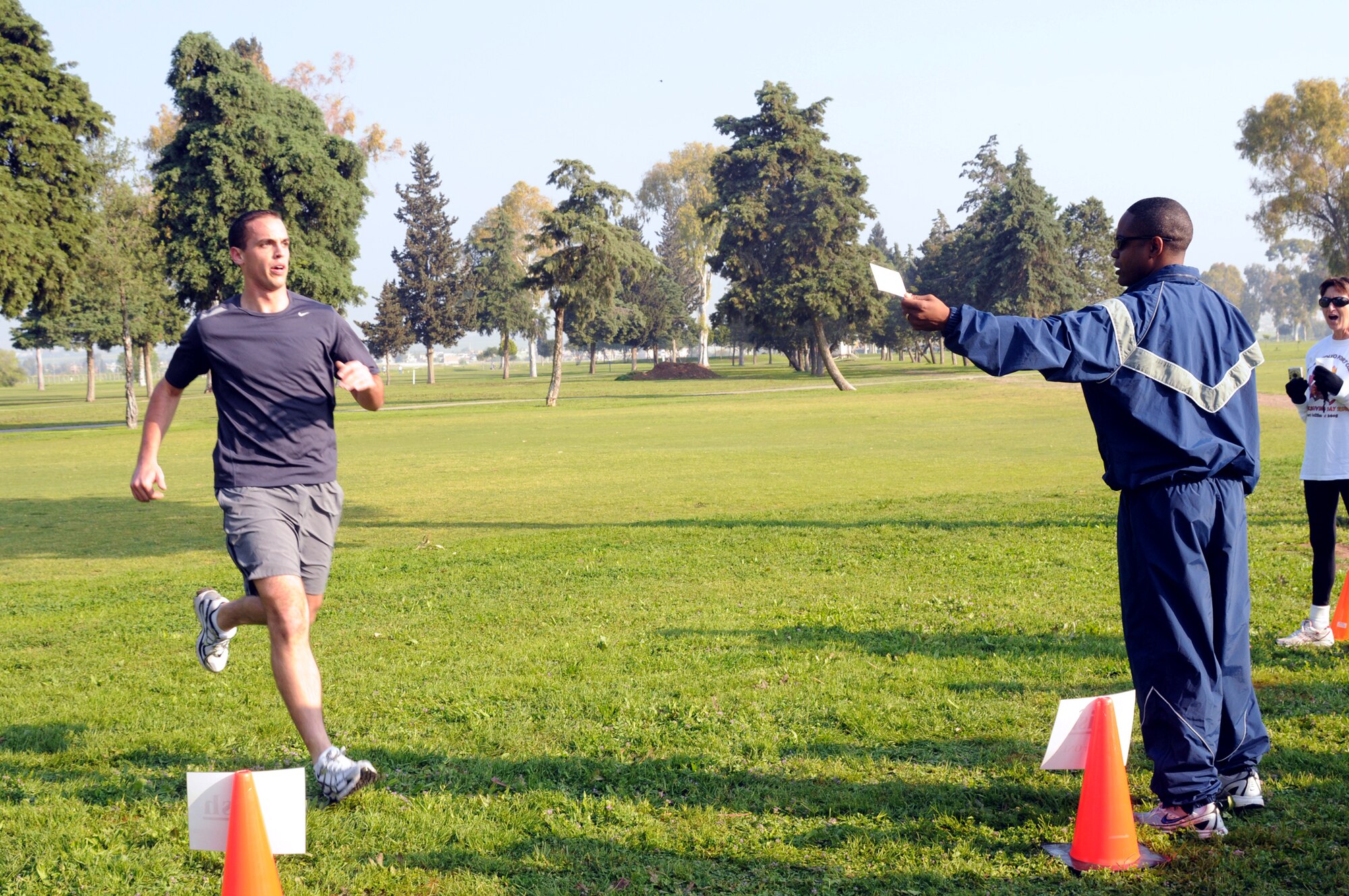 Senior Airman Kyle Gordon, member of Team Triple Threat, crosses the finish line of the Sexual Assault Awareness Month cross country relay race Saturday, April 11, 2009, at the Hodja Lakes Golf Course. The relay was a way to enjoy the Incirlik scenery and get information about the Sexual Assault Prevention and Response program. (U.S. Air Force photo/Senior Airman Heather Stanton)