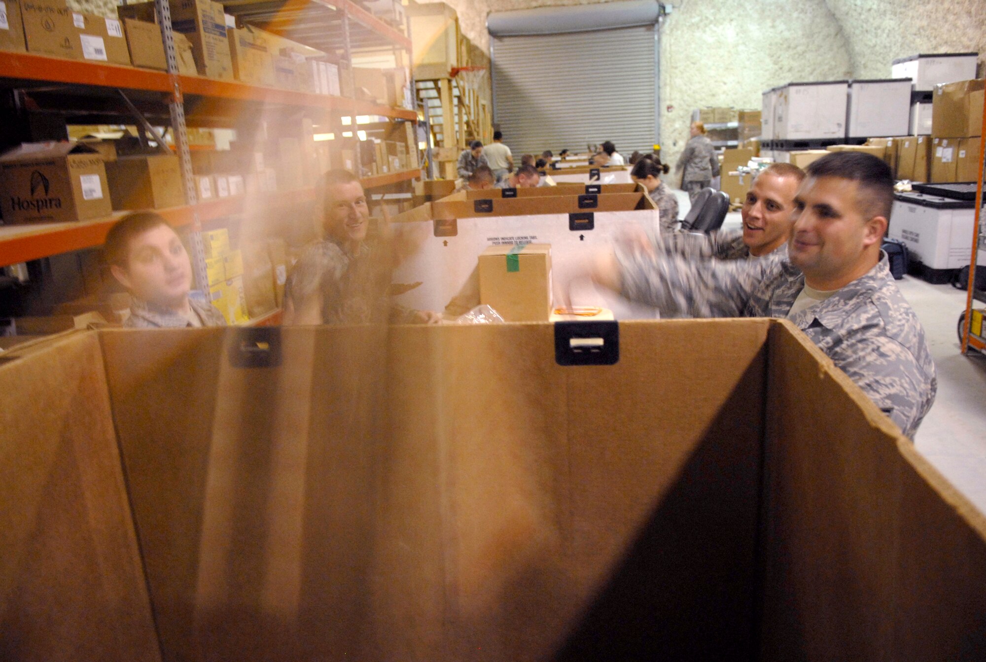 Senior Airman Jonathan Bose, Senior Airman Nathaniel Hildreth, Staff Sgt. William Powell, Staff Sgt. Brandon Elkins, all from the 379th Expeditionary Communications Squadron, toss completed Individual First Aid Kits they have assembled into a bin, Apr. 9, 2009, at an undisclosed location in Southwest Asia.  The volunteers put in the required items, checking for anything out of date to ensure the kits being distributed to personnel down range are effective.  Airman Hildreth hails from Cincinnati, Ohio and is deployed from Ramstein Air Base, Germany.  Sergeant Powell hails from Ridgeland, Miss. and is deployed from McCord Air Force Base, Wash.  Sergeant Elkins hails from Norwalk, Wis. and is deployed from Tyndall Air Force Base, Fla.  Airman Bose hails from Terre Haute, Ind. and is deployed from the 181st Intelligence Air National Guard Wing, Hulman Field, Ind.  All are deployed in support of Operations Iraqi and Enduring Freedom and Combined Joint Task Force - Horn of Africa.  (U.S. Air Force photo/Senior Airman Andrew Satran/released)