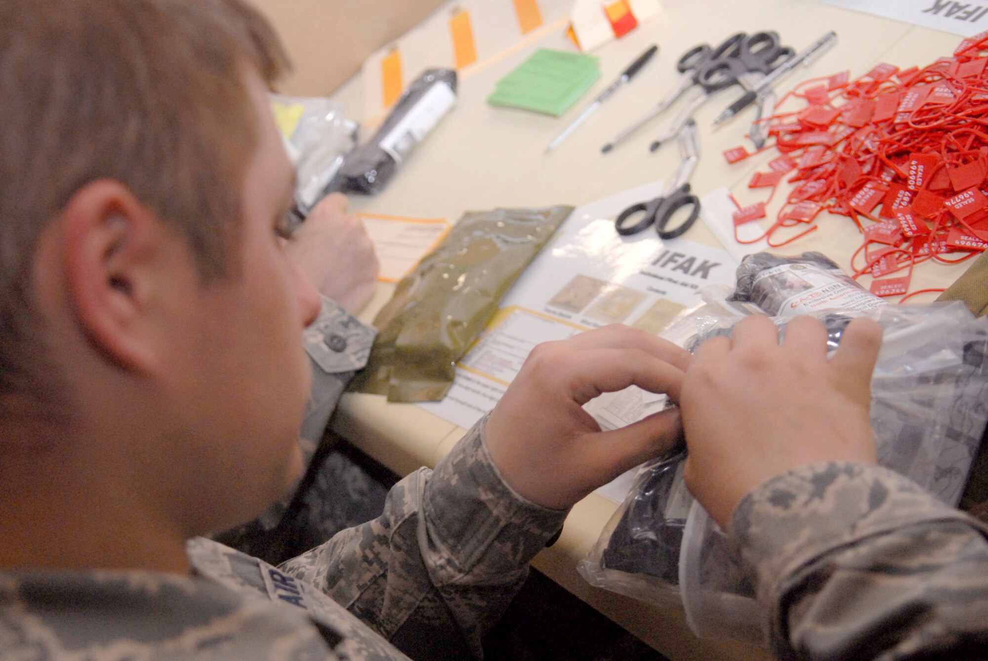 Senior Airman Jonathan Bose, from the 379th Expeditionary Communications Squadron, volunteers to help assemble Individual First Aid Kits (IFAK), Apr. 9, 2009, at an undisclosed location in Southwest Asia.  The volunteers put in the required items, checking for anything out of date to ensure the kits being distributed to personnel down range will be effective if needed.  The IFAKs are given to Airmen who are going to locations throughout the U.S. Central Command's Area of Responsibility.  Airman Bose hails from Terre Haute, Ind. and is deployed from 181st Intelligence Air National Guard Wing Hulman Field, Ind., in support of Operations Iraqi and Enduring Freedom and Combined Joint Task Force - Horn of Africa.  (U.S. Air Force photo/Senior Airman Andrew Satran/released)