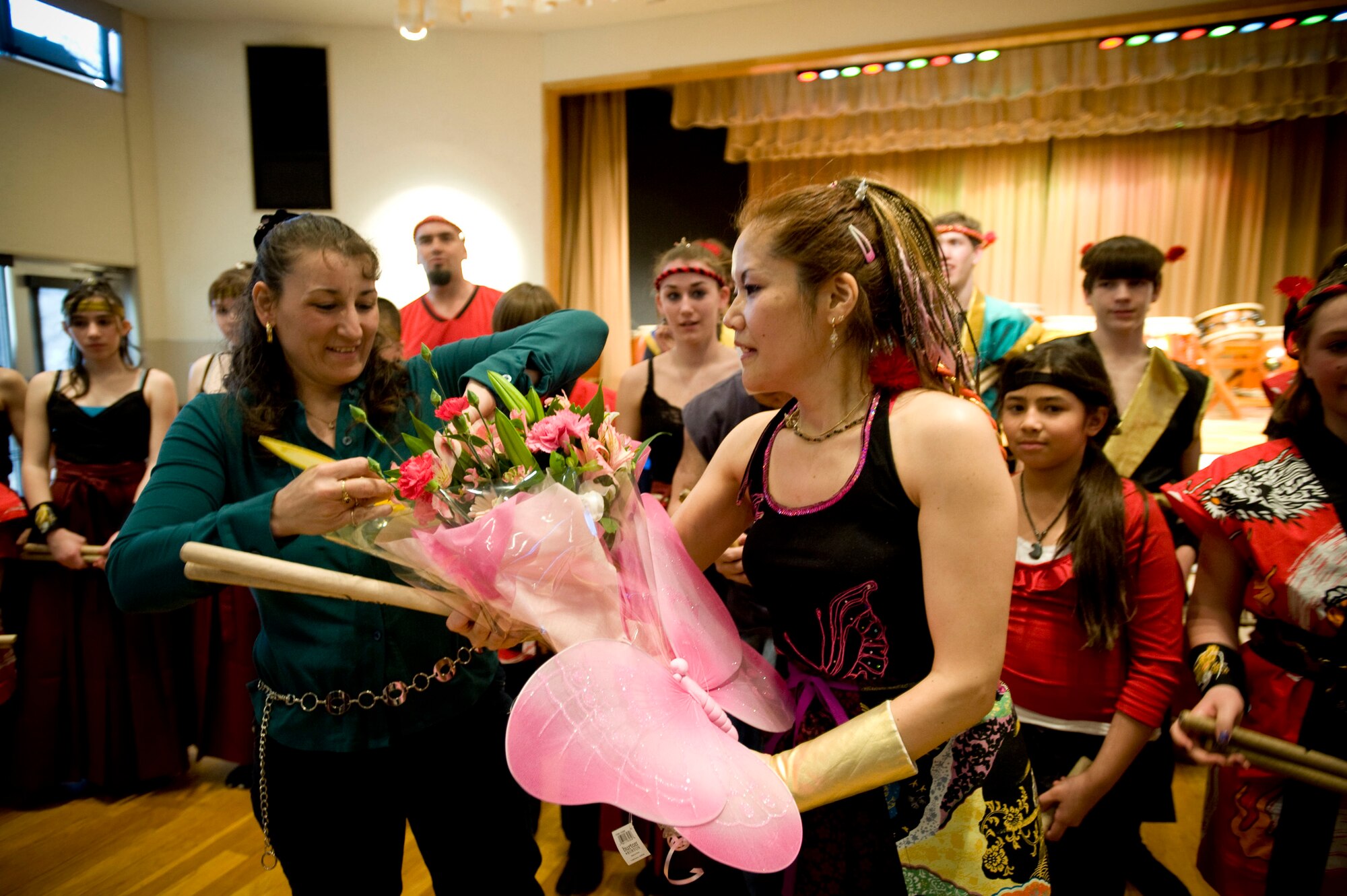 MISAWA AIR BASE, Japan -- Tech. Sgt. Jeanine Steele, mother of two members of the Dragon-Eagle Taiko team, presents flowers to the team's instructor, Kazuko Igarashi, following the tenth anniversary performance at the Mokuteki Community Center March 28, 2009. The team had a party after the show to celebrate the anniversary and a good performance. (U.S. Air Force photo by Staff Sgt. Samuel Morse)