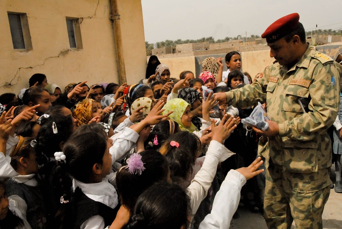 An Iraqi soldier gives stuffed bears to children at the Al Bestor School in Hariwab, Iraq, April 2, 2009. Iraqi soldiers, supported by U.S. soldiers from Military Transition Team 336, delivered toys, pencils, paper, pens, erasers, markers, notebooks, pencil cases, backpacks, a freezer and a message on safety, time management and organization skills to the girls, ages 6 to 12. U.S. Army photo by Sgt. Debralee P. Crankshaw