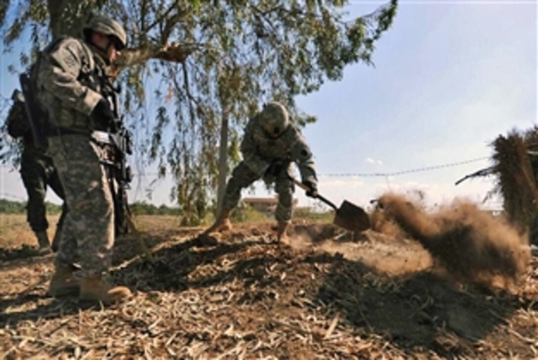 A U.S. Army soldier uses a shovel to dig and inspect a suspected weapons cache during a patrol with Iraqi army soldiers near the town of Sheik Hammad Village, Iraq, April 10, 2009. The U.S. soldiers are assigned to the 28th Infantry Division's Company A, 1st Battalion, 111th Infantry Regiment, 56th Stryker Brigade Combat Team.
