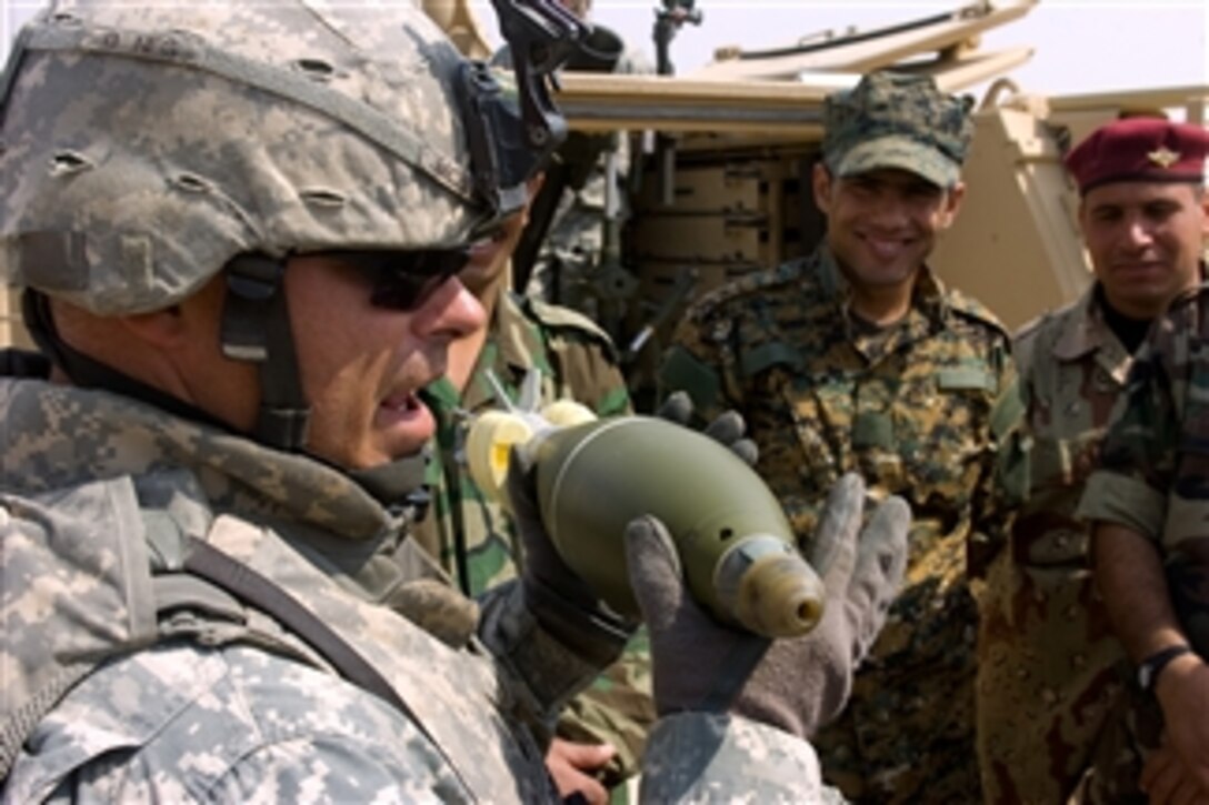 U.S. Army Sgt. 1st Class Michael McBride (left) explains the different parts of a 120mm mortar shell to Iraqi soldiers from 1st Battalion, 46th Brigade, 12th Infantry Division on a mortar range during a field training exercise in the Saber Range, outside Mansurya village, Diyala province, Iraq, on April 4, 2009.  McBride is assigned as a Platoon Sergeant for Gunfighter Platoon, Headquarters and Headquarters Company, 1st Squadron, 8th Cavalry Regiment, 2nd Brigade Combat Team, 1st Cavalry Division.  