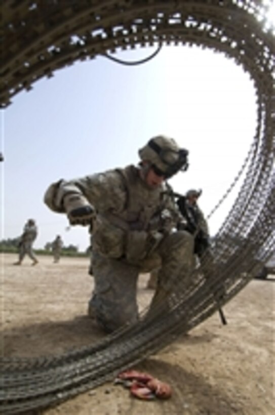U.S. Army Spc. Zachary Sexton deploys concertina wire around the entrance to a makeshift medical clinic in Abu Bakr, Iraq, on April 7, 2009.  Soldiers are preparing the facility for medical personnel from the Iraqi Ministry of Health, who will provide free medical care and consultation to area residents.  Sexton is assigned to 1st Battalion, 24th Infantry Regiment, 1st Stryker Brigade Combat Team, 25th Infantry Division.  