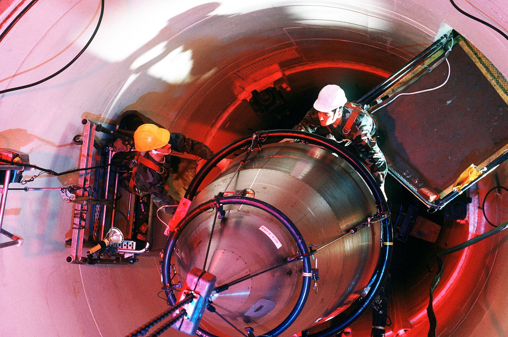 Airmen guide a Minuteman III re-entry system onto a missile guidance set in September 1990. (U.S. Air Force photo)