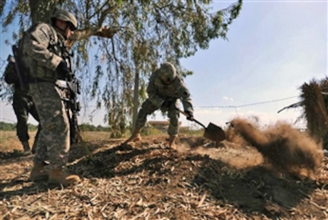 A U.S. Army soldier uses a shovel to dig and inspect a suspected weapons cache during a patrol with Iraqi army soldiers near the town of Sheik Hammad Village, Iraq, April 10, 2009. The U.S. soldiers are assigned to the 28th Infantry Division's Company A, 1st Battalion, 111th Infantry Regiment, 56th Stryker Brigade Combat Team.