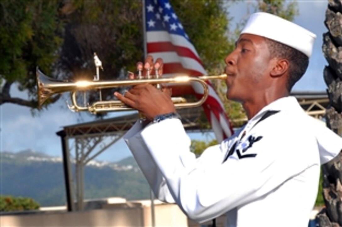 U.S. Navy Petty Officer 3rd Class Anthony Chiles, a musician, plays taps during a memorial ceremony April 6 at the National Memorial Cemetery of the Pacific, Honolulu, April 6, 2009. The ceremony commemorated the 67th Philippine national holiday Araw ng Kagitingan or Day of Valor, which honors Filipino-American troops during World War II.