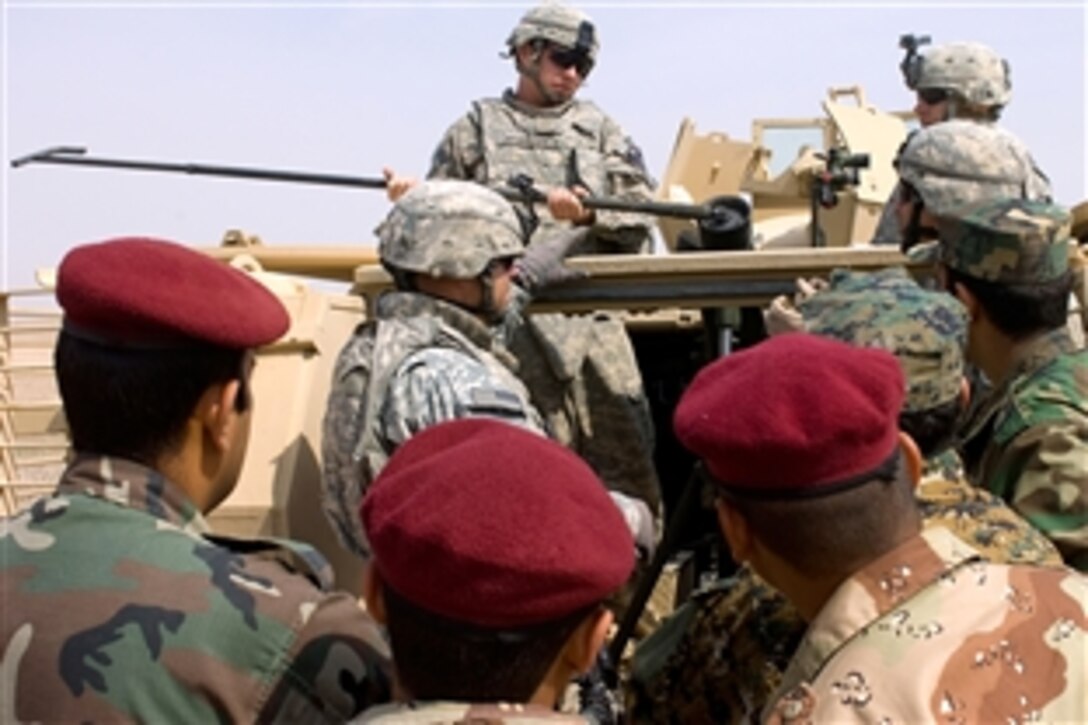 U.S. Army Sgt. 1st Class Michael McBride demonstrates how to use a round extractor to Iraqi soldiers during a field exercise on Saber Range outside Mansurya village in Diyala province, Iraq, April 4, 2009. McBride is assigned to the 1st Calvary Division's Headquarters Company, 8th Calvary Regiment, 2nd Brigade Combat Team.