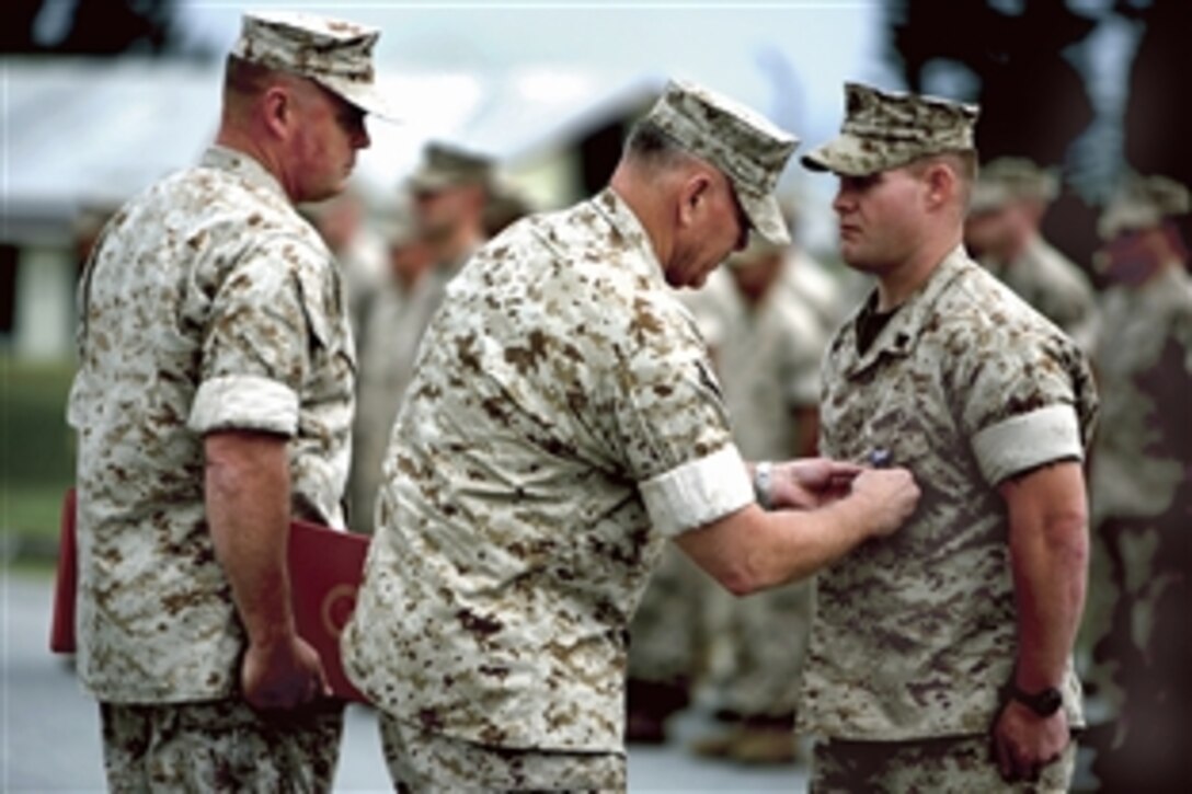 U.S. Marine Lt. Gen. Richard C. Zilmer, center, accompanied by Sgt. Maj. Samuel Schmidt, pins the Silver Star Medal on Cpl. Jason Jones, a logistics and combat service support specialist, during an awards ceremony on Camp Schwab, Okinana, Japan, April 2, 2009. Jones received the medal for his actions during a firefight in eastern Afghanistan. Zilmer is commanding general of III Marine Expeditionary Force and Schmidt is the sergeant major of the 4th Marine Regiment, 3rd Marine Division.
