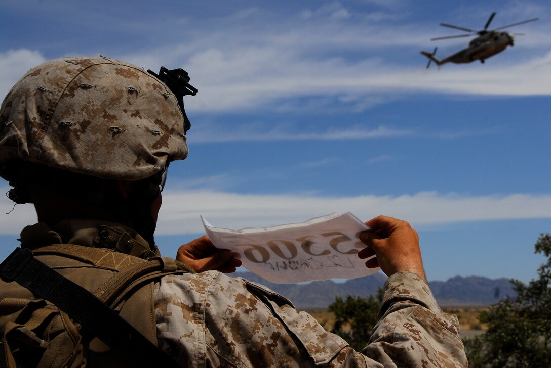 Sgt. Jared Leiss, a squad leader with 3rd Battalion, 9th Marine Regiment, shows his squad's number for the pilot of an MV-22 Osprey who picked up the Marines at during an air assault exercise, April 13, 2009, in a training area east of Marine Corps Air Station Yuma, Ariz. The Quincy, Ohio, native and his squad of approximately 10 Marines were transported to a landing zone in the Blue Mountain Airfield for a live-fire exercise and to secure the airfield. The Camp Lejeune, N.C., battalion is scheduled to conclude their training in Yuma with a battalion-sized helicopter-borne assault exercise in late April, the largest exercise of its type conducted in approximately 10 years.