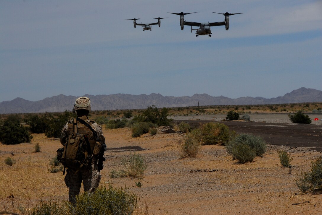 A Marine from K Company, 3rd Battalion, 9th Marine Regiment, watches two MV-22 Ospreys land at Marine Corps Air Station Yuma, Ariz., Auxiliary Airfield 2 during an air assault exercise for the Weapons and Tactics Instructor course April 13, 2009. The Camp Lejeune, N.C., battalion is scheduled to conclude their training in Yuma with a battalion-sized helicopter-borne assault exercise in late April, the largest exercise of its type conducted in approximately 10 years.