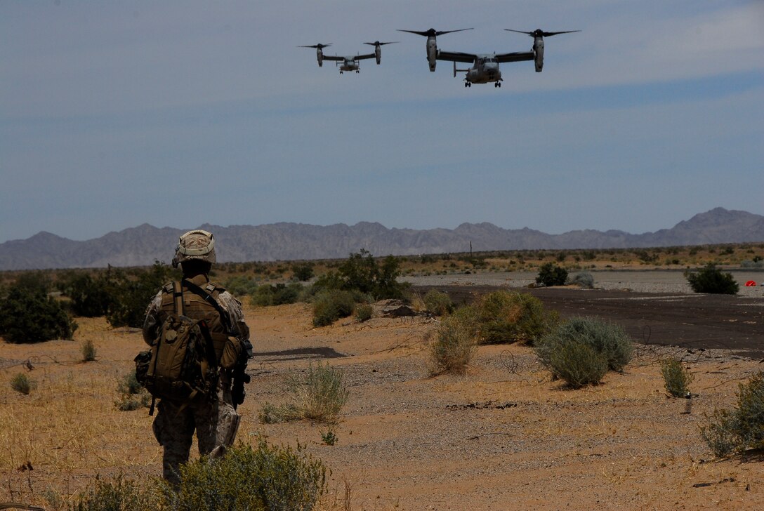 A Marine from K Company, 3rd Battalion, 9th Marine Regiment, watches two MV-22 Ospreys land at Marine Corps Air Station Yuma, Ariz., Auxiliary Airfield 2 during an air assault exercise for the Weapons and Tactics Instructor course April 13, 2009. The Camp Lejeune, N.C., battalion is scheduled to conclude their training in Yuma with a battalion-sized helicopter-borne assault exercise in late April, the largest exercise of its type conducted in approximately 10 years.