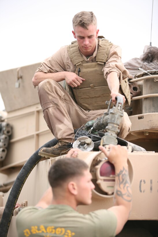 Lance Cpl. Alex Cox, a gunner with 1st platoon, Company C, 1st Tank Battalion, refuels his tank after returning from a live-fire training exercise at Noble Pass training area April 14.