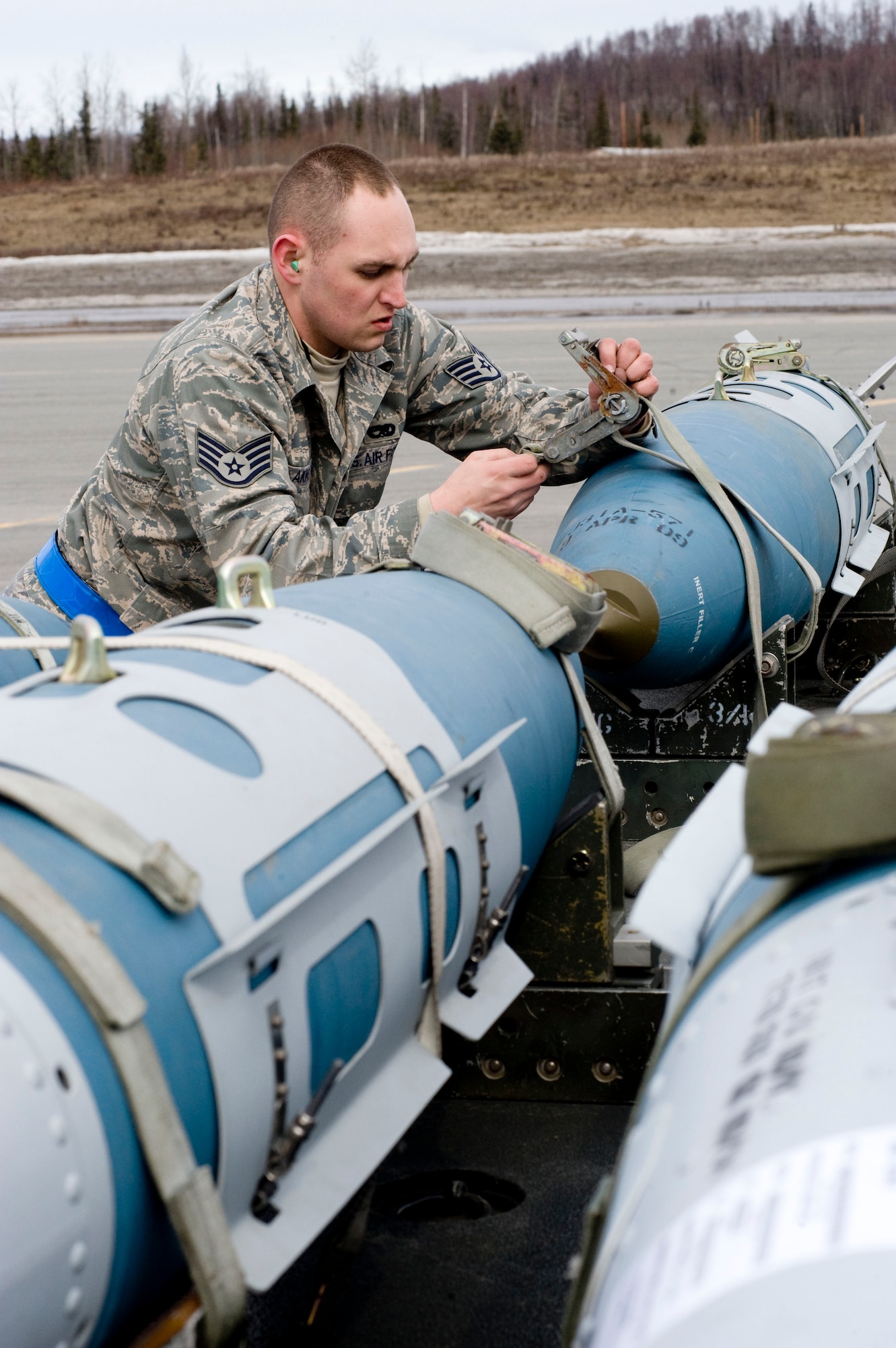 ELMENDORF AIR FORCE BASE, Alaska-- Staff Sgt. Justin Akins unstraps a Joint Direct Attack Munition (JDAM) that will be loaded onto an F-22 Raptor April 14, 2009.  Akins is from the 525th Aircraft Maintenance Unit ensures that the first JDAM dropped by 525th Fighter Squadron is successful. (U.S. Air Force photo by Senior Airman Jonathan Steffen)