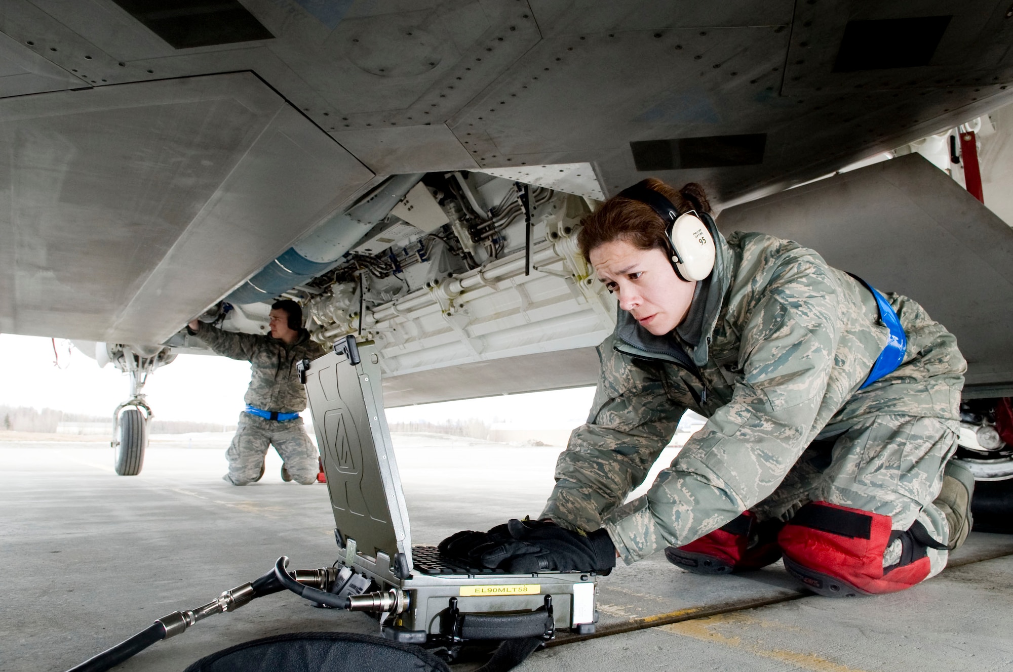 ELMENDORF AIR FORCE BASE, Alaska-- Staff Sgt. Geneva Rumbaugh looks over her check list after loading Joint Direct Attack Munition (JDAM) onto an F-22 Raptor while Airman 1st Class Justin Baker inspects the JDAM April 14, 2009.  Rumbaugh and Airman Baker from the 525th Aircraft Maintenance Unit ensure that the first JDAM dropped by 525th Fighter Squadron is successful. (U.S. Air Force photo by Senior Airman Jonathan Steffen)