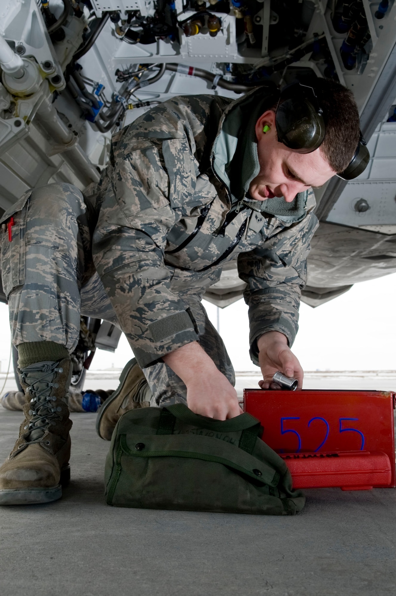 ELMENDORF AIR FORCE BASE, Alaska-- Airman 1st Class Justin Baker grabs tools to setup an F-22 Raptor weapons bay for the loading of a Joint Direct Attack Munition (JDAM) April 14, 2009. Airman Baker from the 525th Aircraft Maintenance Unit ensures that the first JDAM dropped by 525th Fighter Squadron is successful. (U.S. Air Force photo by Senior Airman Jonathan Steffen)