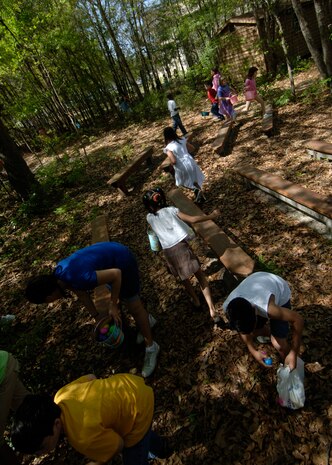 Children in the 8-to-12 age group search for eggs in a challenging environment behind Youth Programs during the Easter egg hunt April 11. More than 7,000 total eggs were used throughout the four age groups in the Easter egg hunt. (U.S. Air Force photo/Senior Airman Timothy Taylor)