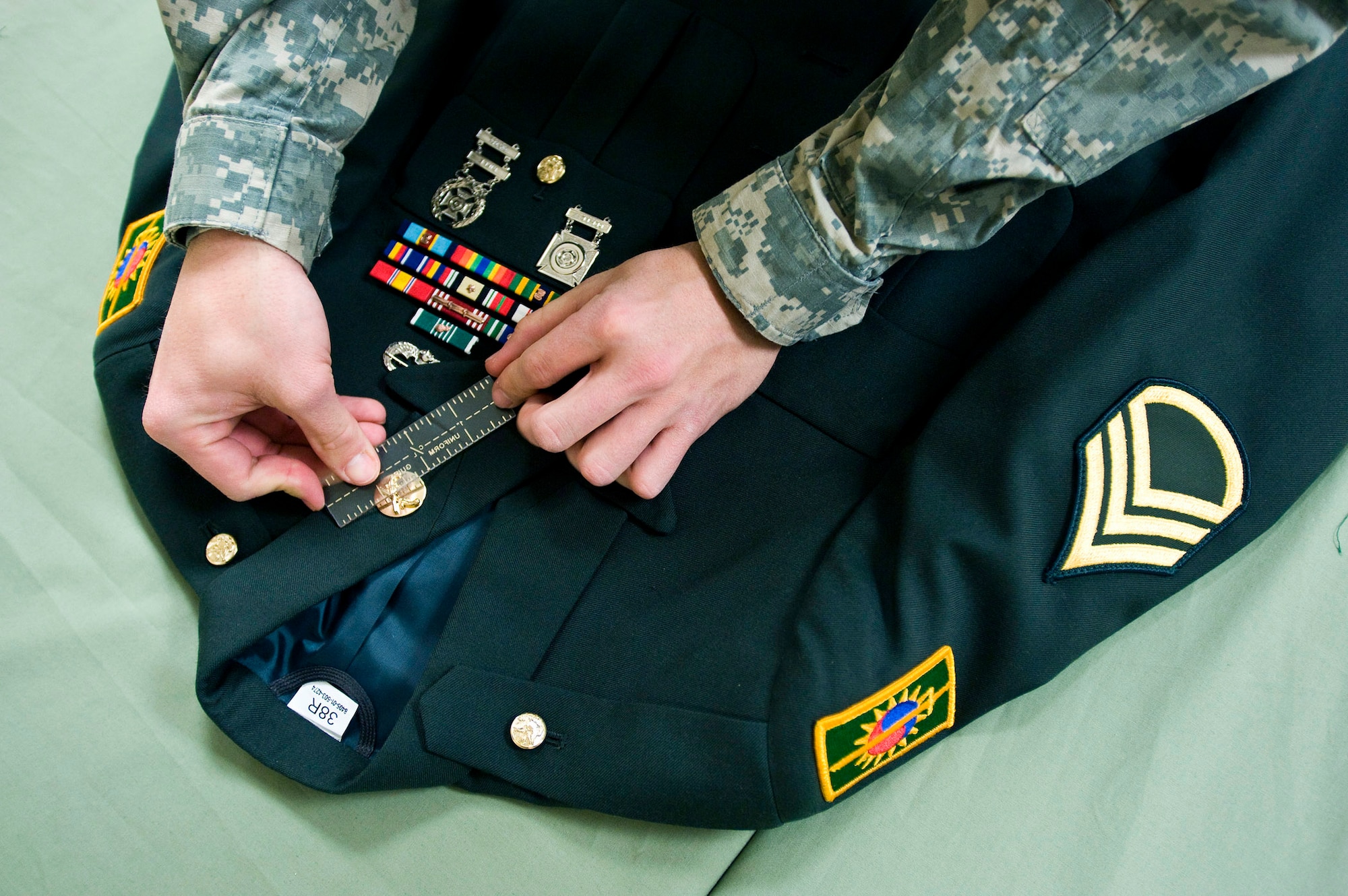 Specialist Noel Rivera, a mortuary affairs specialist, prepares a U.S. Army service dress uniform for a fallen solider. Servicemembers in the uniform section of the Air Force Mortuary Affairs Operations Center at Dover Air Force Base, Del., prepare uniforms for the fallen heroes and work with military escorts for the dignified-transfer-of-remains process.  Specialist Rivera is deployed from the Army Reserve, 311th Quartermaster Company in Puerto Rico. (U.S. Air Force photo/Staff Sgt. Bennie J. Davis III)