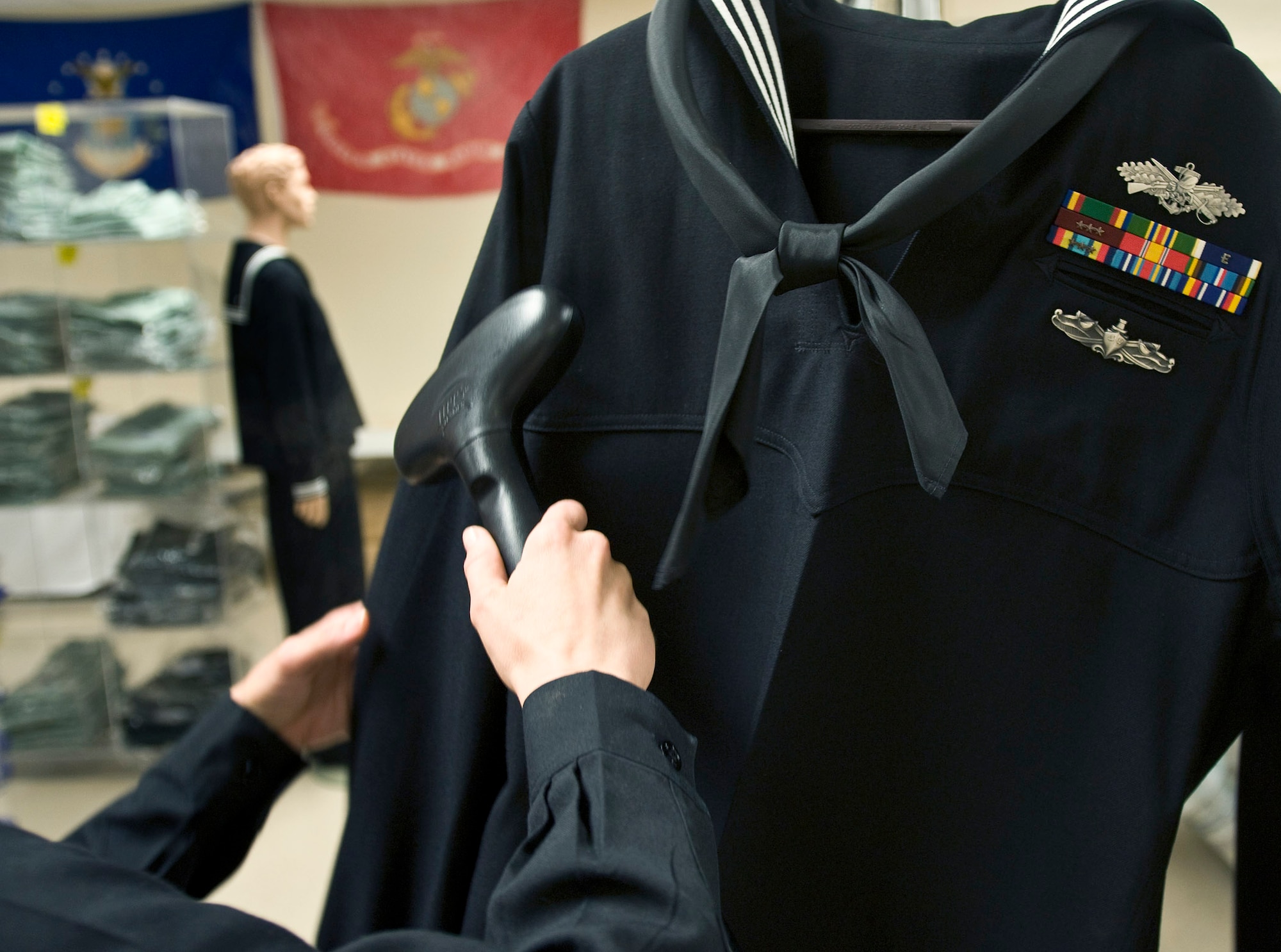 Petty Officer 2nd Class Danielle Van Orden steam cleans a U.S. Navy uniform for a fallen sailor March 31. Petty Officer Van Orden is the Navy and Marine Corps liaison for the uniform section of the Air Force Mortuary Affairs Operations Center at Dover Air Force Base, Del. Service liaisons prepare uniforms for remains and work with military escorts for the dignified transfer of remains process.  (U.S. Air Force photo/Staff Sgt. Bennie J. Davis III)