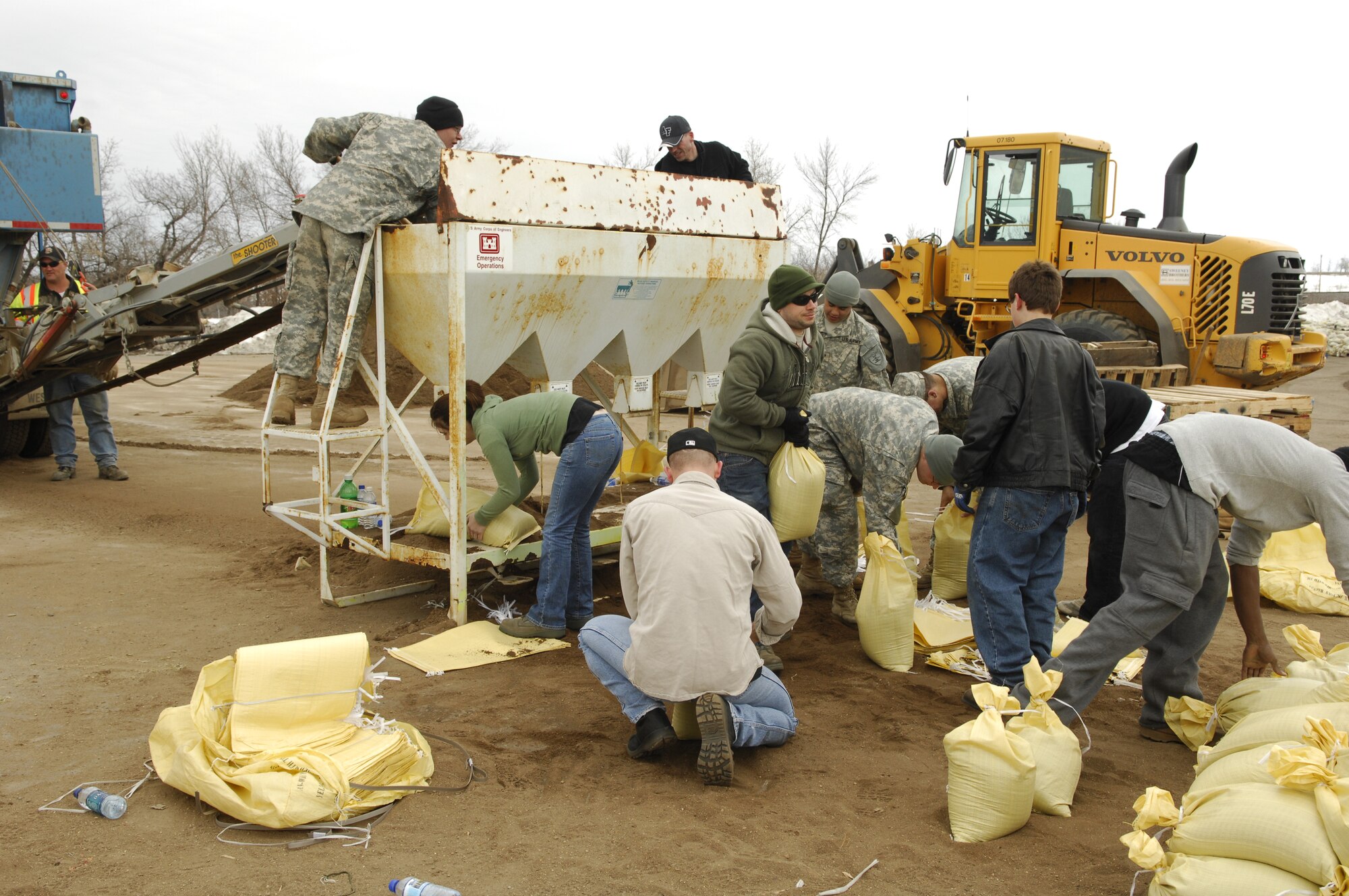 MINOT, N.D. – Airmen from the 5th Operations Support Squadron aircrew flight equipment shop, Army National Guard soldiers and civilians from the surrounding community fill sandbags outside the All Seasons Arena here April 10. The group of volunteers was filling sandbags in preparation of flood relief efforts. (U.S. Air Force photo by Staff Sgt. Thomas Dow)