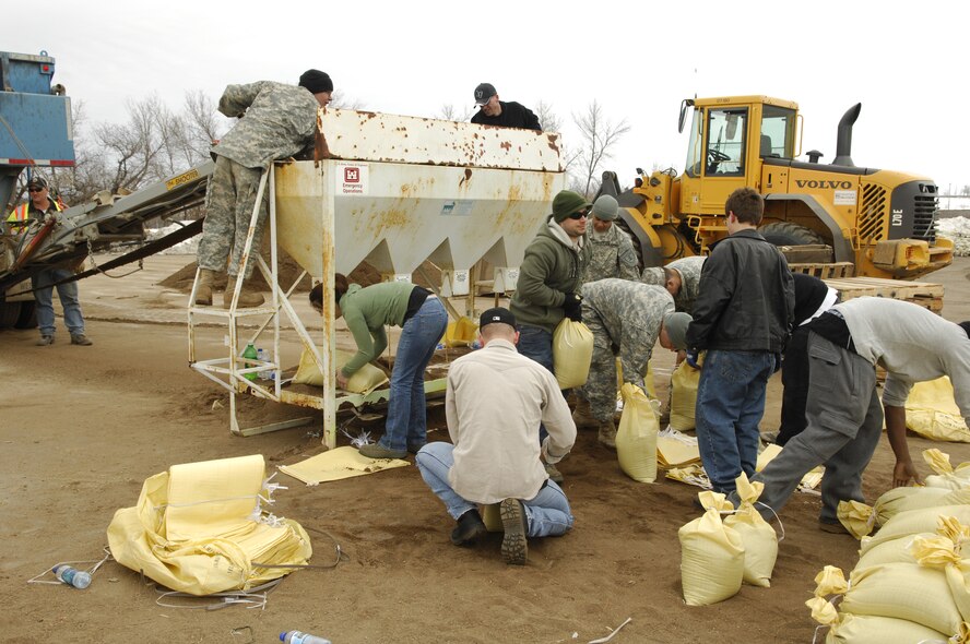 MINOT, N.D. – Airmen from the 5th Operations Support Squadron aircrew flight equipment shop, Army National Guard soldiers and civilians from the surrounding community fill sandbags outside the All Seasons Arena here April 10. The group of volunteers was filling sandbags in preparation of flood relief efforts. (U.S. Air Force photo by Staff Sgt. Thomas Dow)