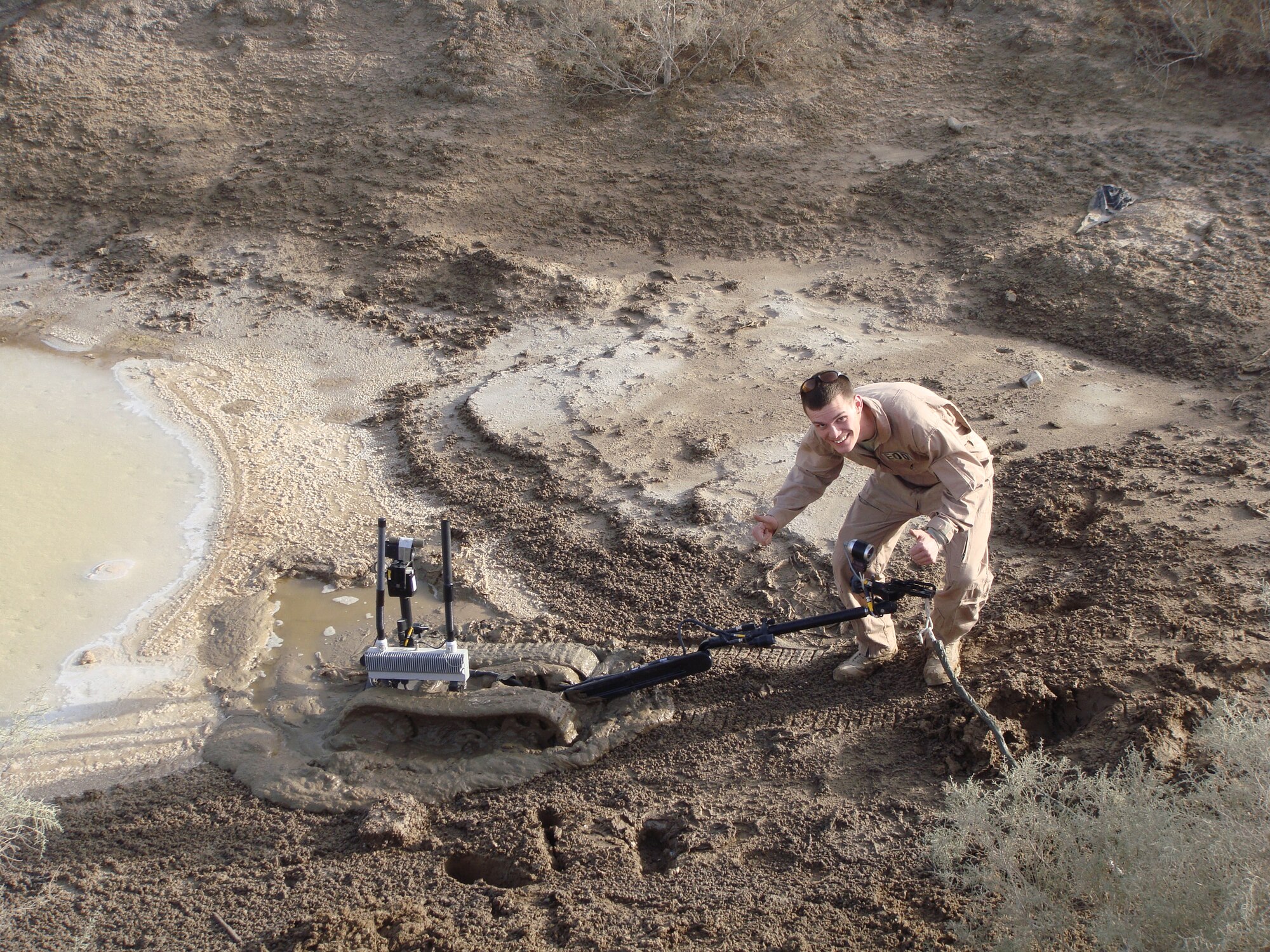Senior Airman Devin Long, explosive ordnance disposal flight, smiles for the
camera after accidentally driving his Talon robot into a cesspool during a
counter-Improvised Explosion Device training operation while deployed an
undisclosed location in the Middle East. EOD Airmen are responsible for
equipment they operate so Airman Long had the task of retrieving his robot. (Courtesy photo)
