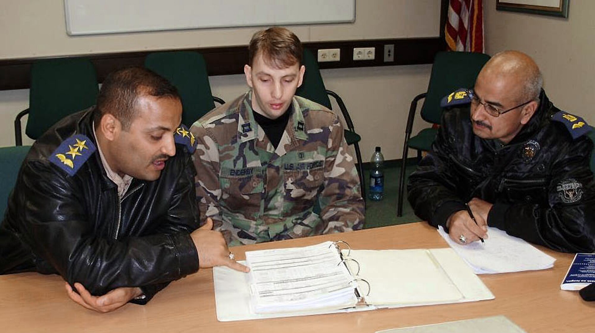Capt. James Enderby shows the Iraqi air force flight surgeons Major (Dr.) Abdulrazzaq and Lt. (Dr.) Hazem the bioenvironmental engineering evaluations of the maintenance shops March 13 at Ramstein Air Base, Germany. Captain Enderby is assigned to the 86th Aerospace Medicine Squadron. (Courtesy photo) 

