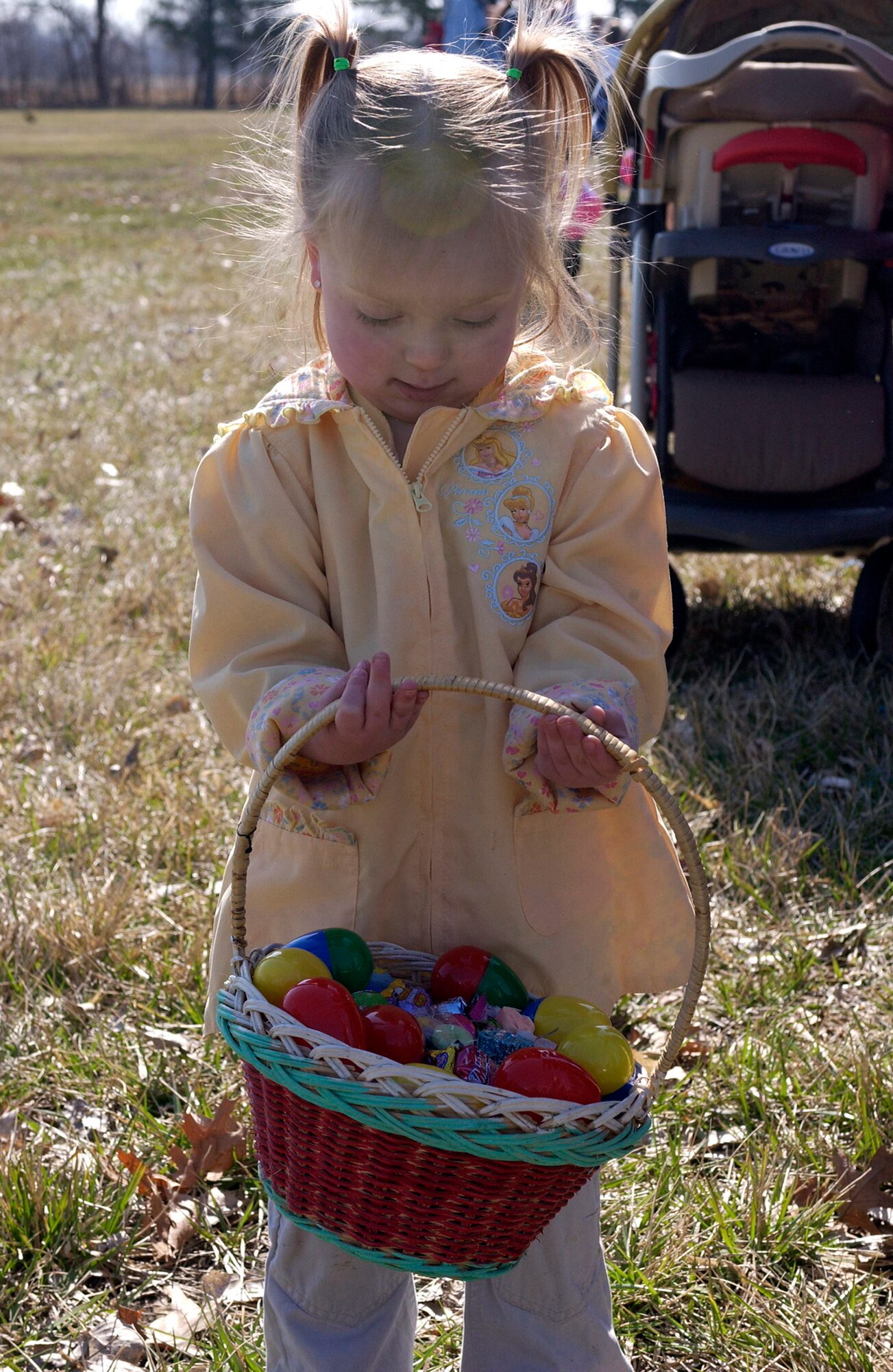 OFFUTT AIR FORCE BASE, Neb. --  Ms. Alexia Kleist admires her hard earned collection of eggs and candy after the 1-3 year old age group finished their turn during Offutt's annual Easter Egg Scramble at the base lake April 11. More than 500 participants and spectators gathered to see the mad dash for eggs and candy. U.S. Air Force Photo By: Staff Sgt. Richard Williams