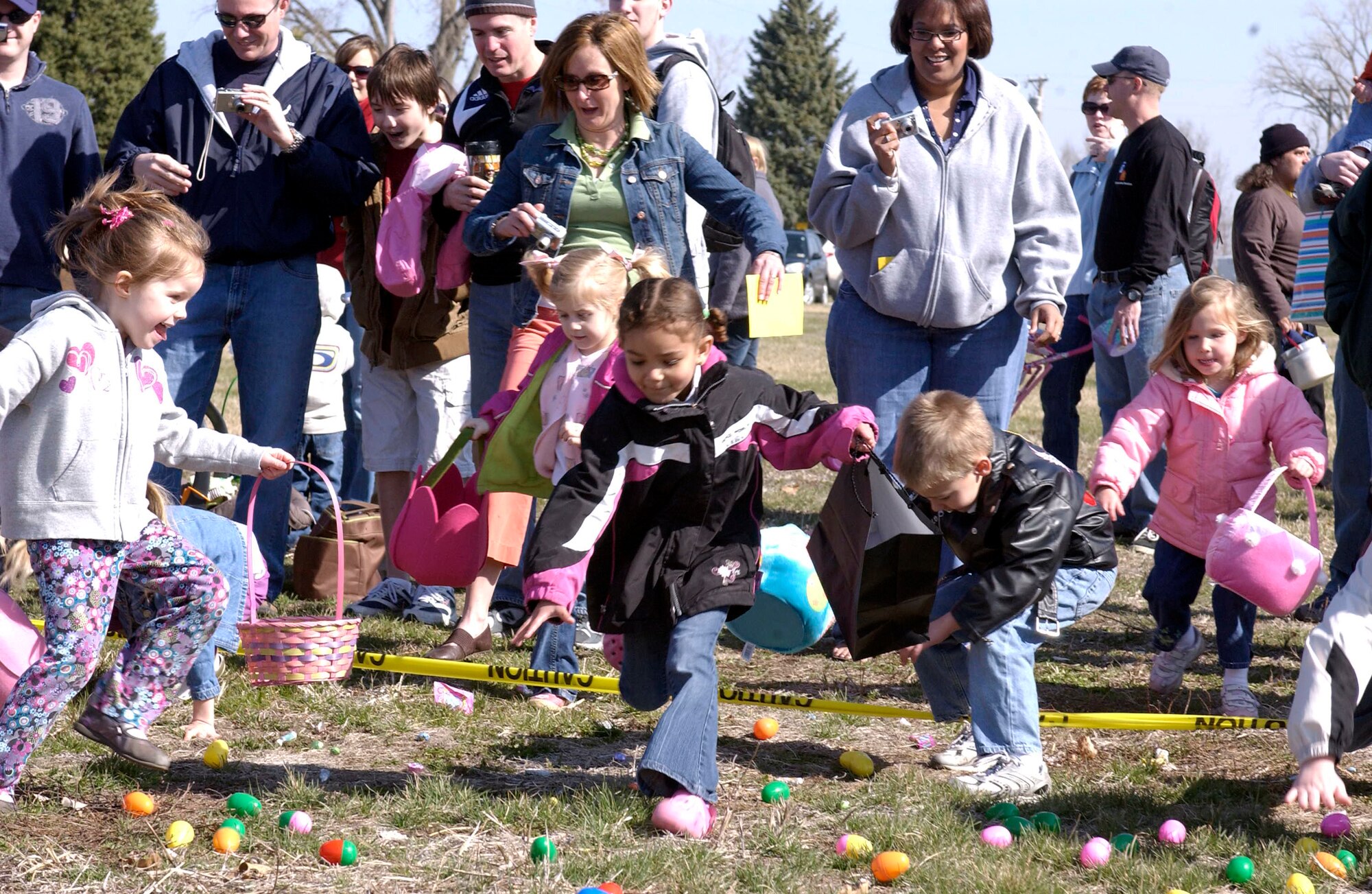 OFFUTT AIR FORCE BASE, Neb. --  Ms. Olivia Hart, reaches down to pick up her first of many eggs during Offutt's annual Easter Egg Scramble at the base lake April 11. The scramble was attended by more than 500 eager egg hunters.  U.S. Air Force Photo By: Staff Sgt. Richard Williams