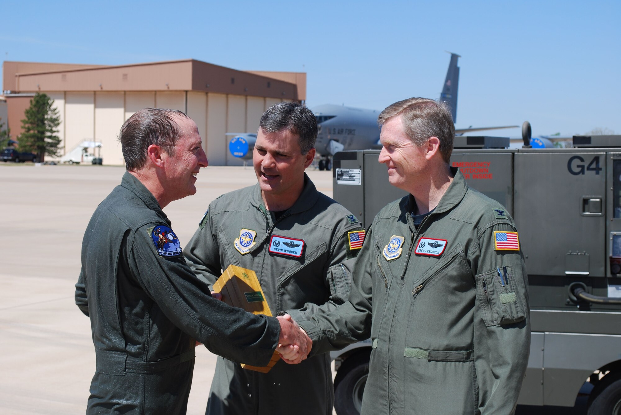 Chief Master Sgt. John Waller, 137th Air Refueling Wing, receives a congratulation handshake from his commander Col. Gregory Fergusson after flying his “fini flight” as an Oklahoma Air National Guard aircrew member. Also congratulating him is the 137th ARW Operations Group commander, Col. Devin Wooden. The chief’s final flight marked several career milestones -- achieving more than 10,000 flying hours combined in the C-130 and KC-135R aircraft, being selected as the new 137th ARW Command Chief, and his 52nd birthday.   The Oklahoma-based unit was the first Air National Guard wing to become an associate wing to an Air Force Reserve Wing. 