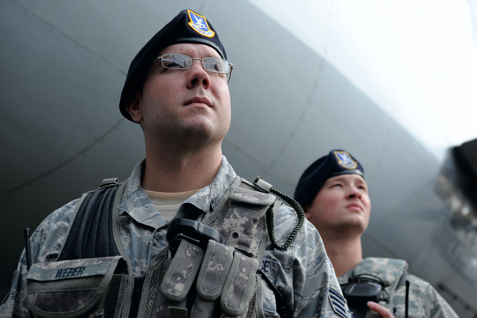 Staff Sgt. Douglas Weber and Senior Airman Adam Klockziem watch and wait while heavy equipment vehicles move into place, April 13, 2009, Eielson Air Force Base Alaska. For security measures, security forces Airmen ensure all equipment removed from the aircraft matches the manifest information. Both Airmen are assigned to the 354th Security Forces Squadron.  (U.S. Air Force photo/Senior Airman Jonathan Snyder)