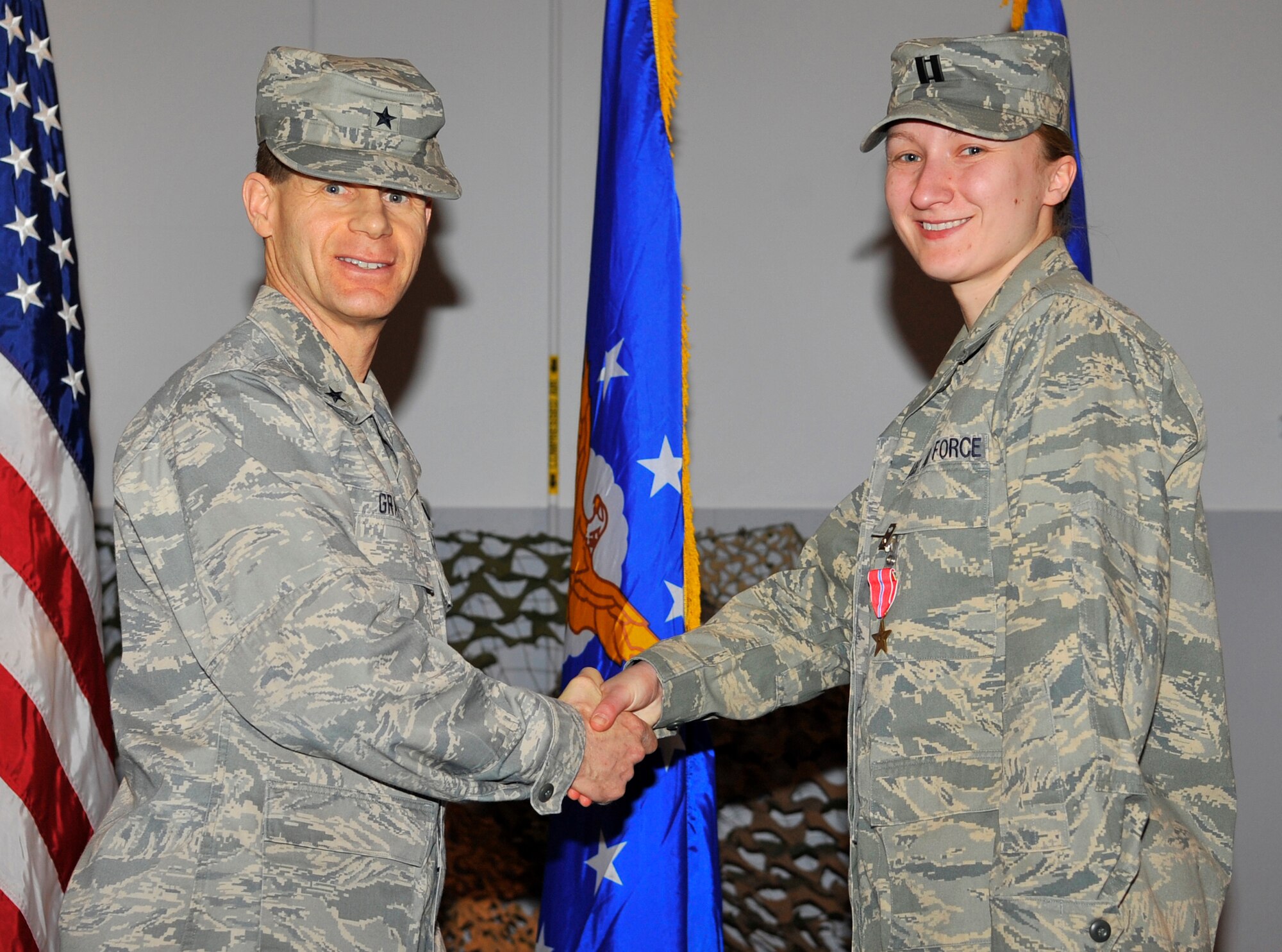 EIELSON AIR FORCE BASE, ALASKA -- Capt. Katarzyna Johnson shakes hands with Brig. Gen. Mark W. Graper after receiving the Bronze Star here during a welcome home ceremony Apr. 10. Captain Johnson was awarded the Bronze Star for his outstanding leadership in Operation Iraqi Freedom. (U.S. Air Force photo/Senior Airman Christopher Boitz)