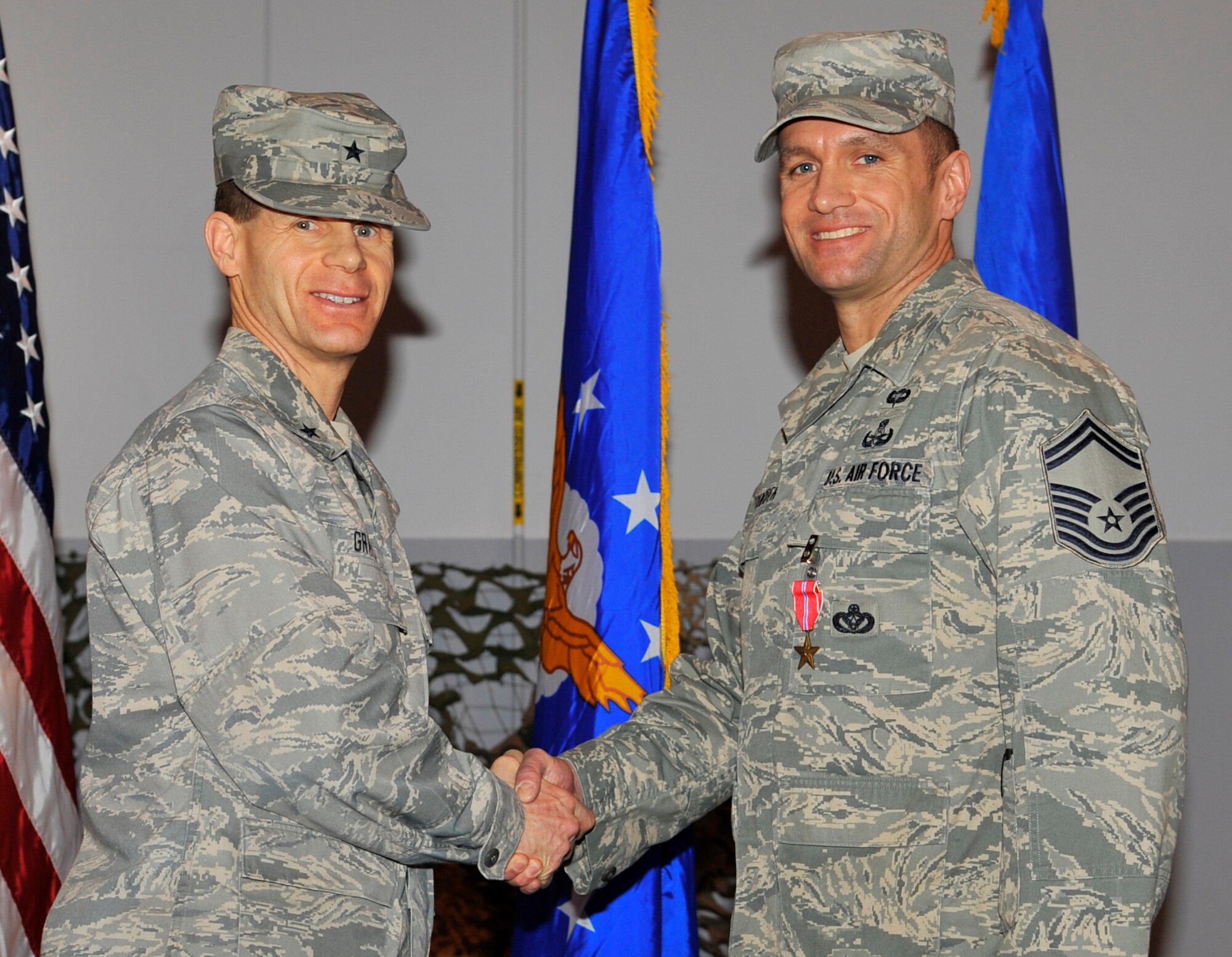 EIELSON AIR FORCE BASE, ALASKA -- Senior Master Sgt. Albert Schnieider shakes hands with Brig. Gen. Mark Graper after receiving the Bronze Star here during a welcome home ceremony Apr. 10. Sgt. Schnieider was awarded the Bronze Star for his outstanding leadership in Operation Iraqi Freedom. (U.S. Air Force photo/Senior Airman Christopher Boitz)