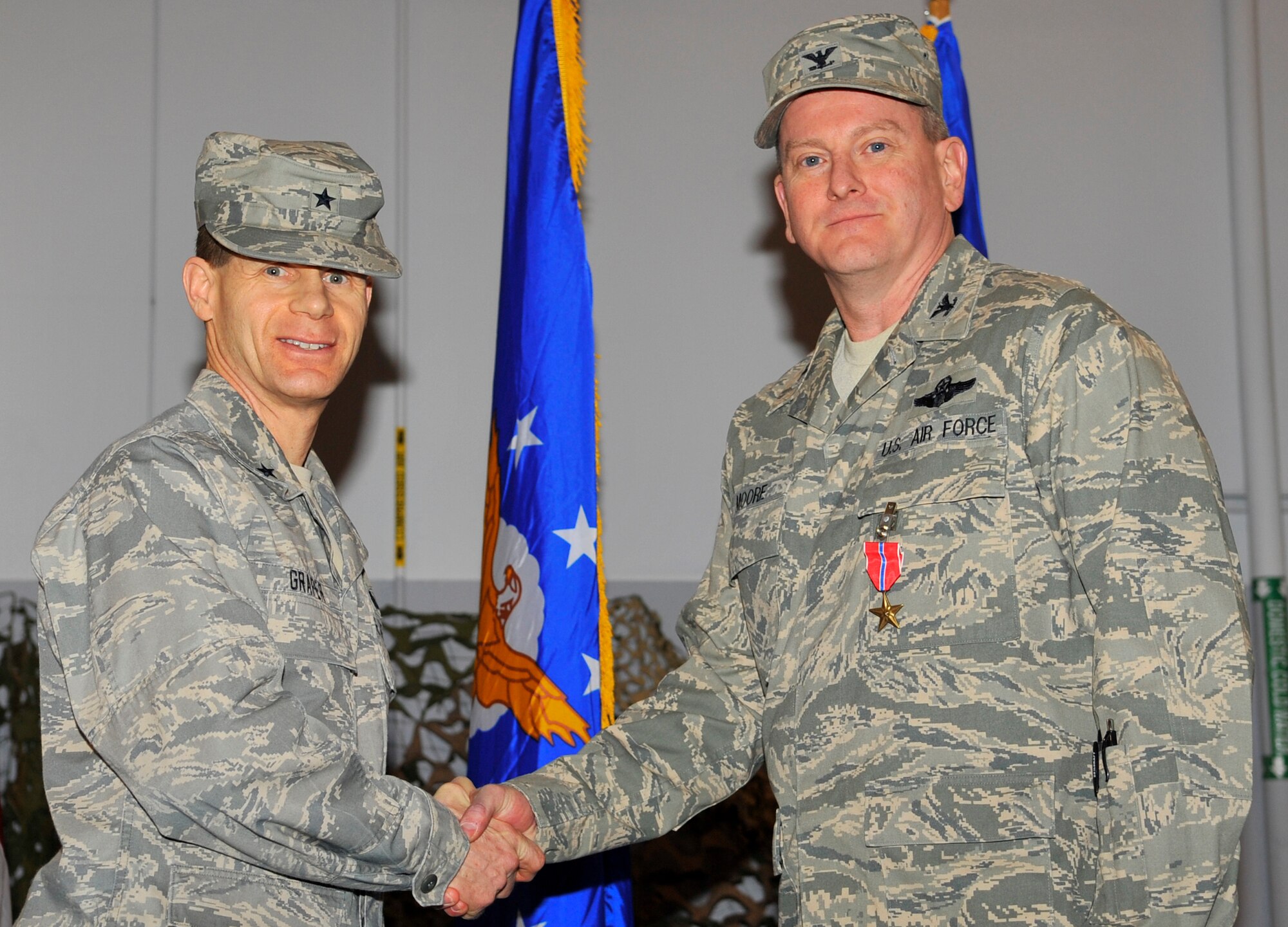 EIELSON AIR FORCE BASE, ALASKA -- Col. Mark Moore shakes hands with Brig. Gen. Mark Graper after receiving the Bronze Star here during a welcome home ceremony Apr. 10. Col. Moore was awarded the Bronze Star for his outstanding leadership in Operation Iraqi Freedom. (U.S. Air Force photo/Senior Airman Christopher Boitz)