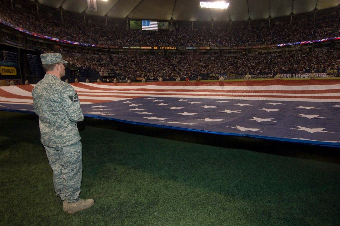 Technical Sgt. Tony Jones from the Joint Force Headquarters of the Minnesota National Guard holds a giant American flag for the national anthem at center field along with over two dozen other Airmen and Soldiers in the home opener for the Minnesota Twins on April 6, 2009. USAF Official Photo by Senior Master Sgt. Mark Moss