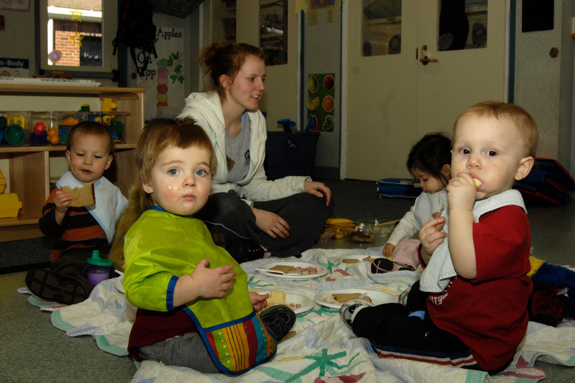 HANSCOM AIR FORCE BASE, Mass. - Children enrolled in the Hanscom Child Development Center enjoy a picnic lunch on April 9, during the Teddy Bear picnic. Pictured along with their Room 15 caregiver, Meaghan Sunde, are from left to right, Edgar Milligan, Kai Mackessy, Mykel Carsetter and Brayden Temperton.  (U.S. Air Force photo by Linda LaBonte Britt)