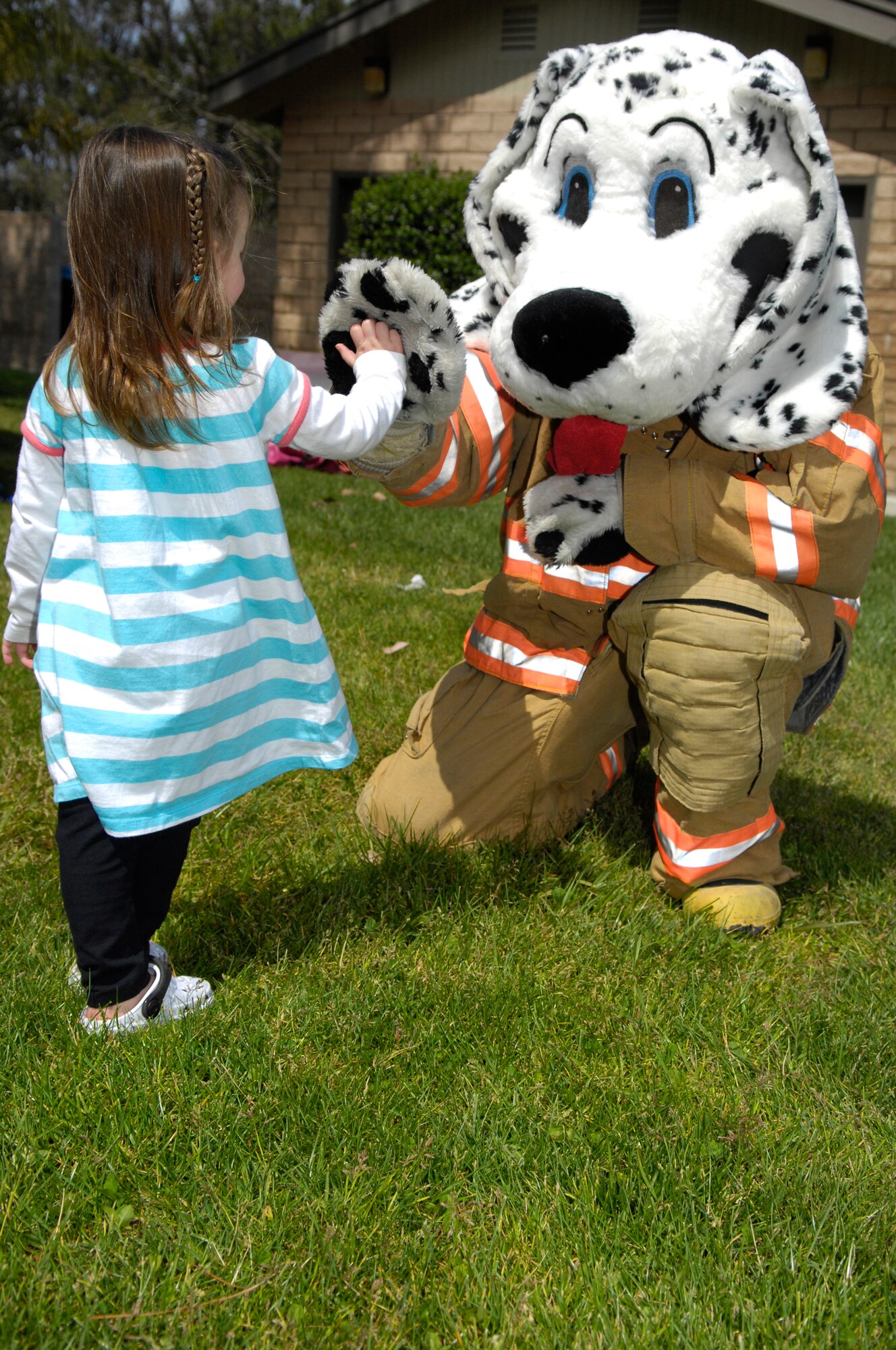 VANDENBERG AIR FORCE BASE, Calif. -- Sparky the Dog interacts with children like Kloe Hendricks during Fire Safety Day April 10 at Cocheo Park here. Sparky and Smokey the Bear were on hand at the event to better teach children about the dangers of fire and how they should react to a fire. The 30th Civil Engineer Squadron's fire departmet hosted the event. (U.S. Air Force photo/Airman 1st Class Andrew Lee) 
 
 
