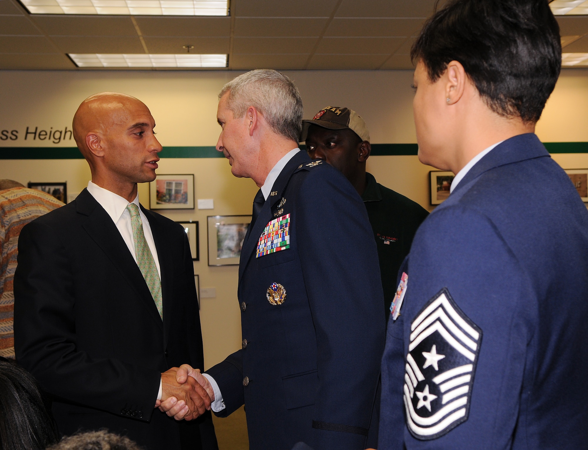 Col. Jon A. Roop (middle), 11th Wing commander, shakes hands with DC Mayor Adrian M. Fenty during a Congressional Heights Community Association meeting April 13 at the Petey Greene Community Service Center, Washington. Colonel Roop and Chief Master Sgt. Robin Johnson, 11th Wing command chief, attended the meeting. Colonel Roop spoke about several upcoming events at Bolling, to include the Fourth of July Jazz Fest, which will be open to the public. Both Colonel Roop and Chief Johnson talked with local residents about the Air Force and Bolling, after the official portion of the meeting. (U.S. Air Force photo by Senior Airman Marleah Miller)