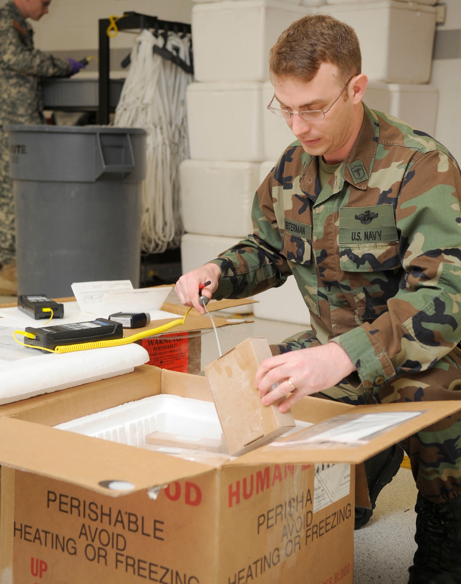 Navy Petty Officer 1st Class Matthew Reiterman, Armed Services Whole Blood Processing Laboratory/East lab technician, uses a digital thermometer to check the temperature of a shipment of blood units from donor centers in the United States March 6. Shipments to the ASWBPL take four-to-seven days to arrive and must stay within the correct temperature range; 1-10 degrees Celsius for liquid red blood cells and less than negative 18 degrees Celsius for frozen blood cells. (U.S. Air Force photo/Carlos Cintron)