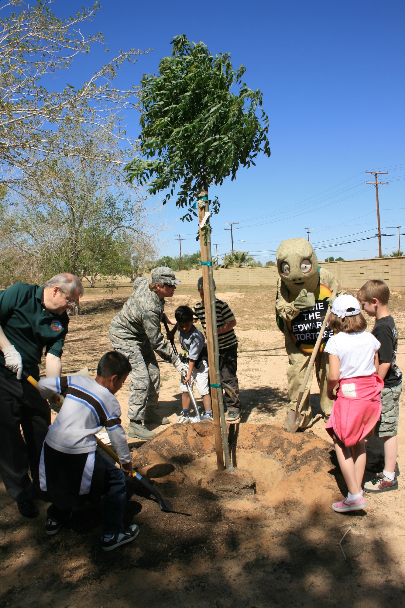 Col. Nancy Reeves-Flores (third from left), 95th Air Base Wing vice commander, together with base children, plants a tree during Earth Day celebration April 17, 2008. Team Edwards will celebrate Earth Day with environmental exhibits, activities and information stations set up at the Center of Excellence April 21, from 10 a.m. to 2 p.m. (U.S. Air Force photo/Mike Cassidy)