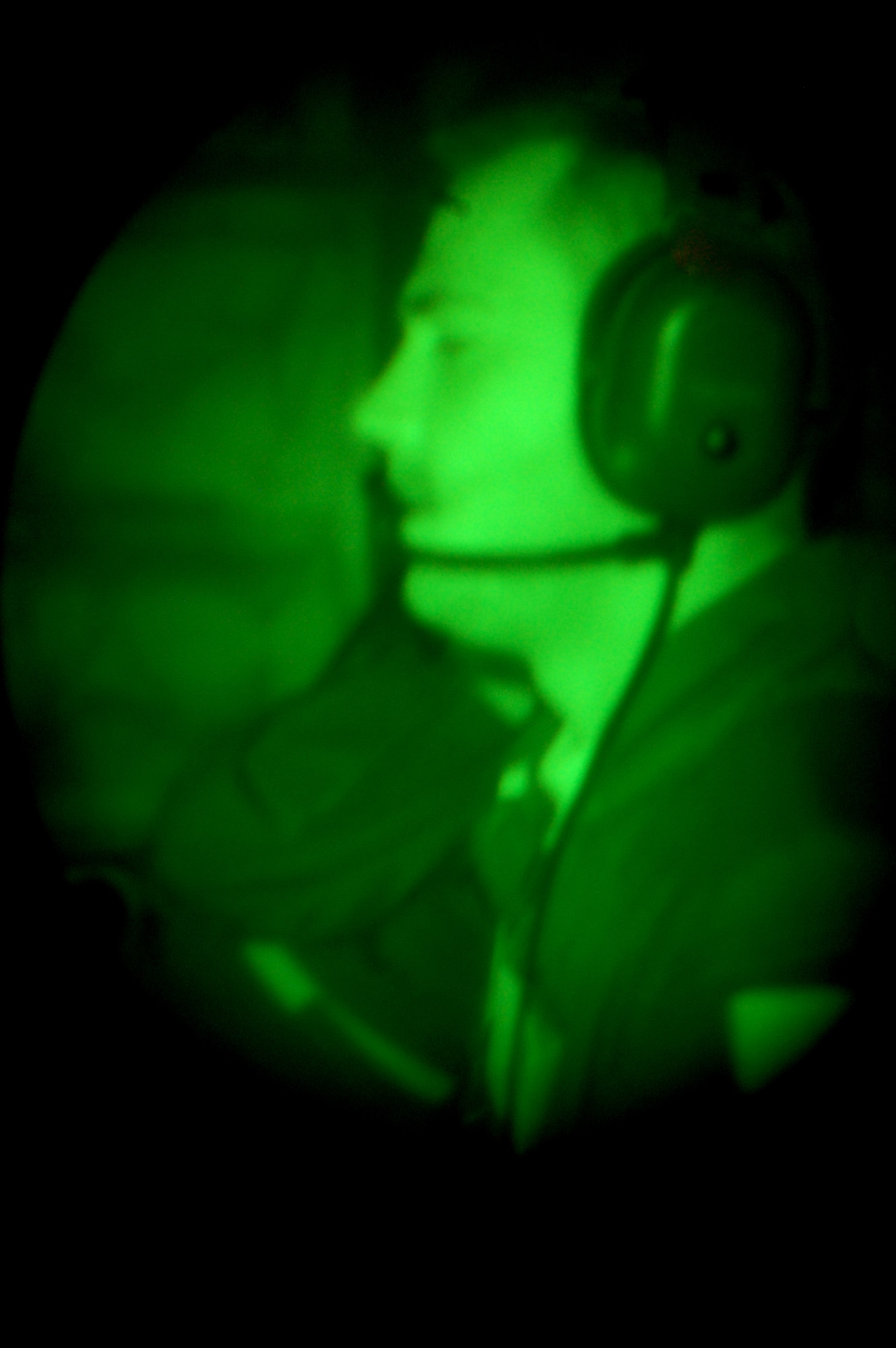 Through the lens of night vision goggles, Staff Sgt. Kenneth Essick, boom operator for the 2nd Air Refueling Squadron on McGuire Air Force Base, N.J., refuels a plane from the boom pod of a KC-10 Extender on April 9, 2009, during an air refueling mission.  On that mission, Sergeant Essick refueled his father's E-8C Joint Surveillance Target Attack Radar System aircraft from the 116th Air Control Wing of Robins AFB, Ga.  His father, Chief Master Sgt. Randal Money, was on his final flight as a flight engineer for the E-8C.  (U.S. Air Force Photo/Tech. Sgt. Scott T. Sturkol)