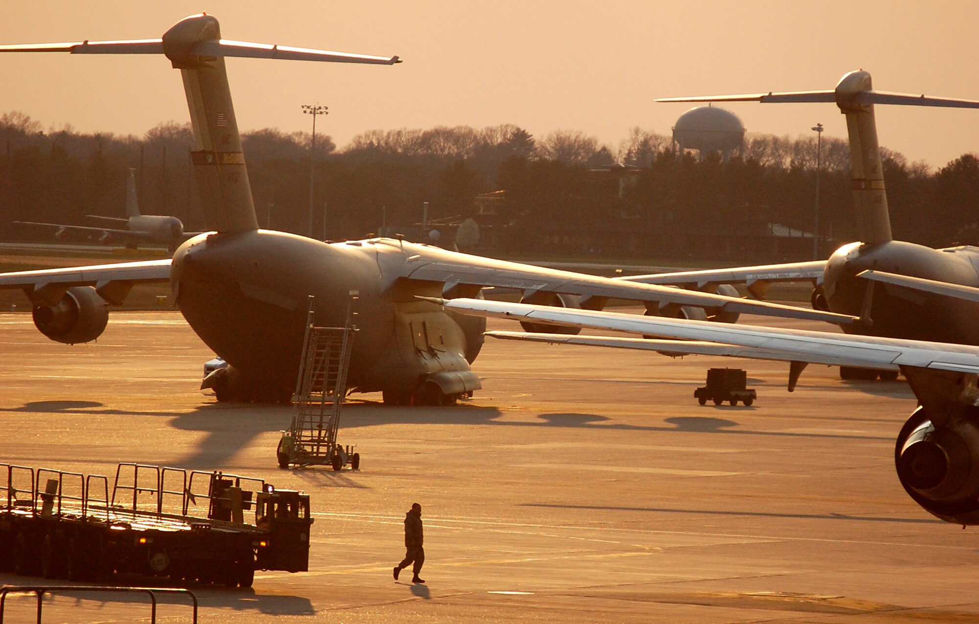 Airmen working in the flightline are shadowed by the sun at McGuire Air Force Base, N.J., on April 9, 2009.  McGuire is one of the bases that helps the Air Force and Air Mobility Command meet the service's global mission to "fly, fight and win...in air, space and cyberspace." (U.S. Air Force Photo/Tech. Sgt. Scott T. Sturkol)