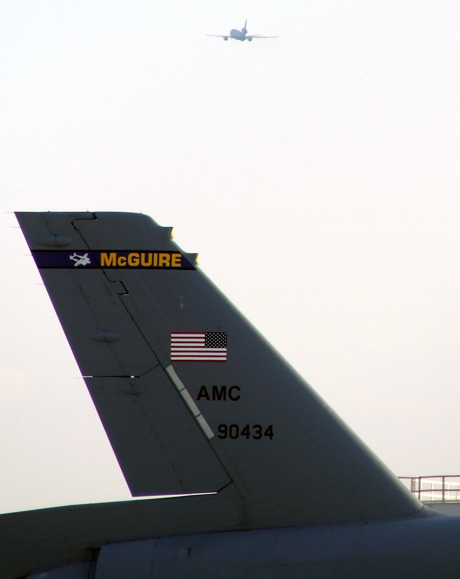 A KC-10 Extender takes off for an air refueling mission over the view of the tail of another KC-10 during operations on the flightline at McGuire Air Force Base, N.J., on April 9, 2009.  The KC-10 Extender, an air refueling plane, is one of types of aircraft at McGuire that helps the Air Force and Air Mobility Command meet the service's global mission to "fly, fight and win...in air, space and cyberspace." (U.S. Air Force Photo/Tech. Sgt. Scott T. Sturkol)