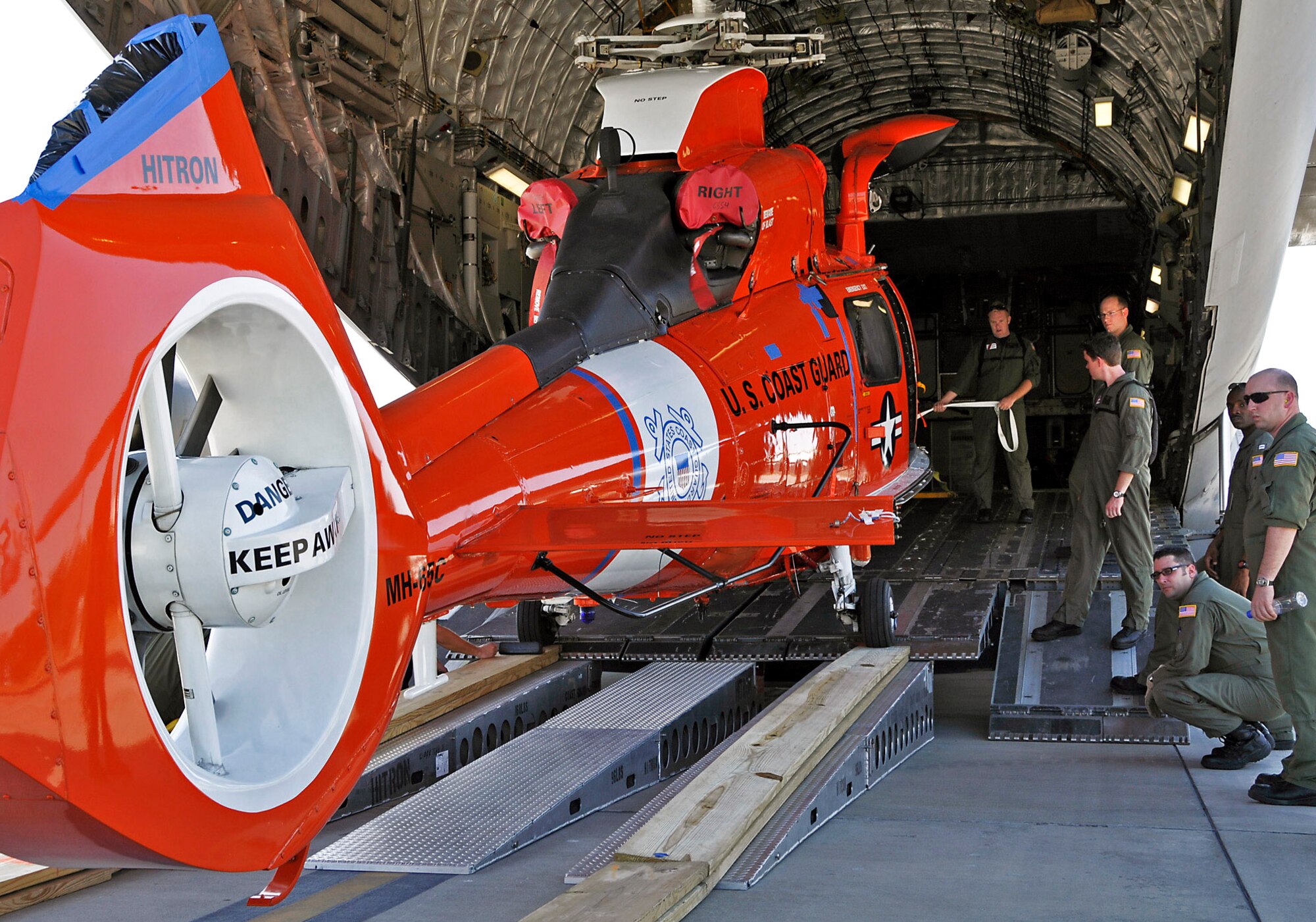 Airmen load a Coast Guard helicopter onto a C-17 Globemaster III April 7 at Charleston Air Force Base, S.C. Two helicopters were delivered to Central America for missions there. The C-17 aircrew is from the Air Force Reserve's 315th Airlift Wing from Charleston AFB. (U.S. Air Force photo/Capt. Chett Collier) 
