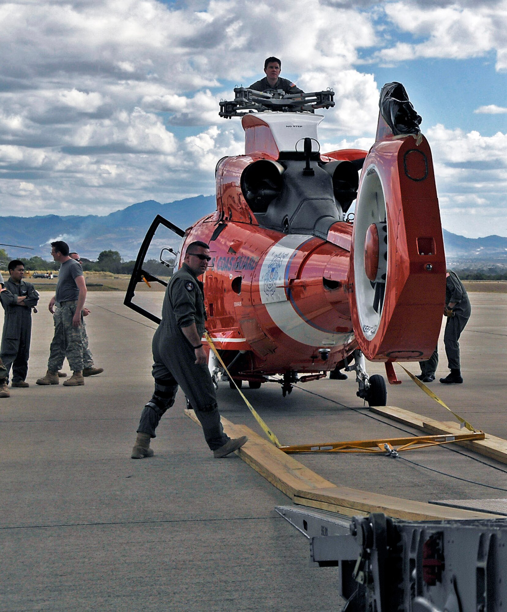 Airmen prepare to load a Coast Guard helicopter aboard a C-17 Globemaster III April 7 at Charleston Air Force Base, S.C. Two helicopters were delivered to Central America for missions there. The C-17 aircrew is from the Air Force Reserve's 315th Airlift Wing from Charleston AFB. (U.S. Air Force photo/Capt. Chett Collier) 
