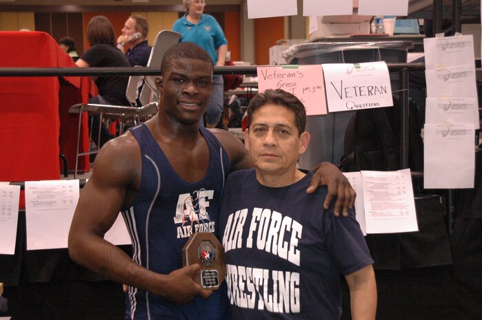 Airman Kevin Justin, 96 Security Forces Squadron, Eglin Air Force Base, and Rich Estrella, Air Force wrestling coach and 2008 Olympic Games coach, take a photo with the "stopsign" 2nd place placque at the FILA Junior National Wrestling tournament April 8 in Las Vegas.
