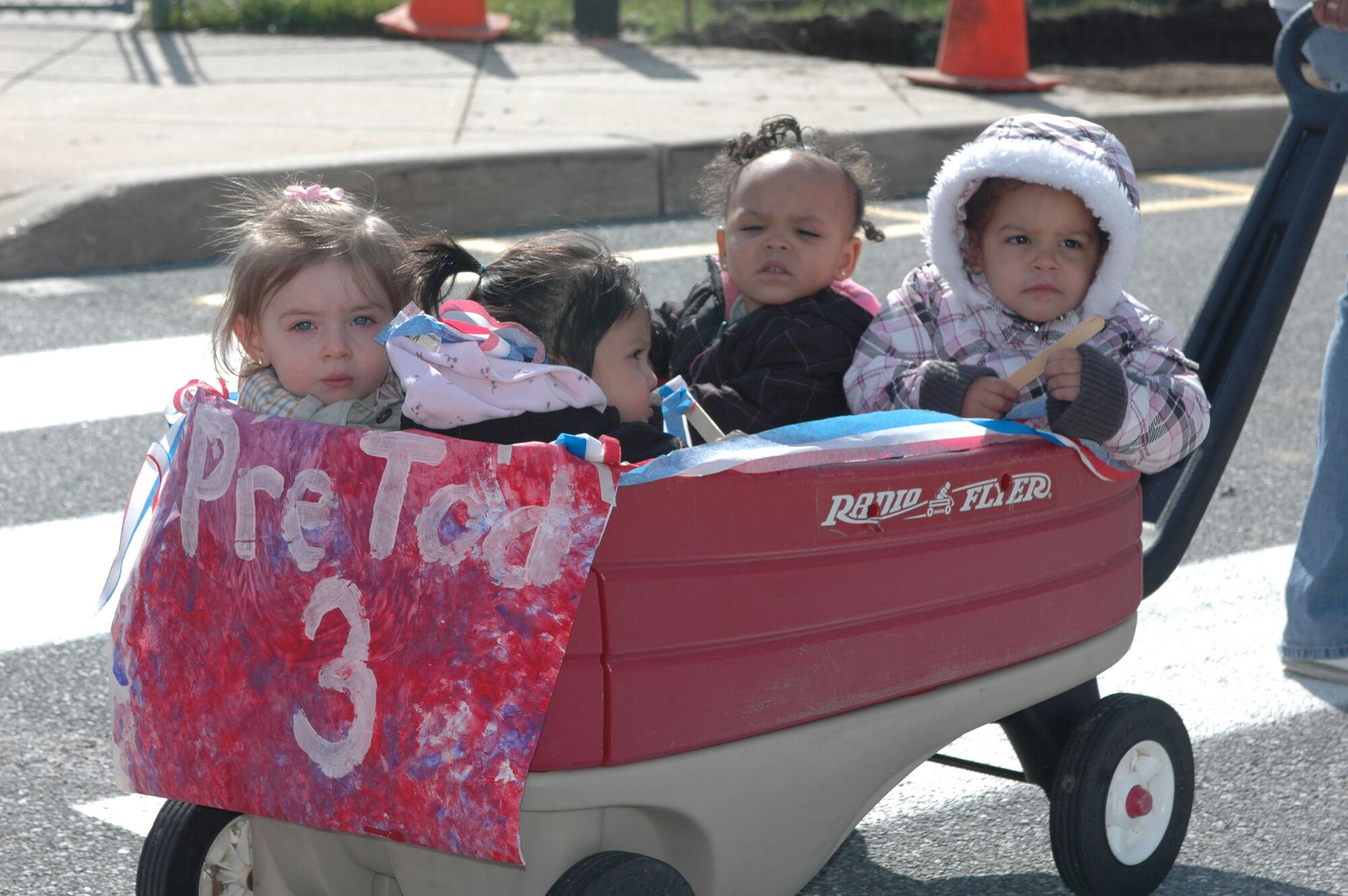 Four 3-year old children from the Dover Air Force Base Child Development Center ride in a wagon during a patriotic-themed parade in honor of Month of the Military Child, April 8. This CDC-hosted event has become an annual tradition and was attended by numerous family members. (U.S. Air Force photo/ Master Sgt. Veronica Aceveda)