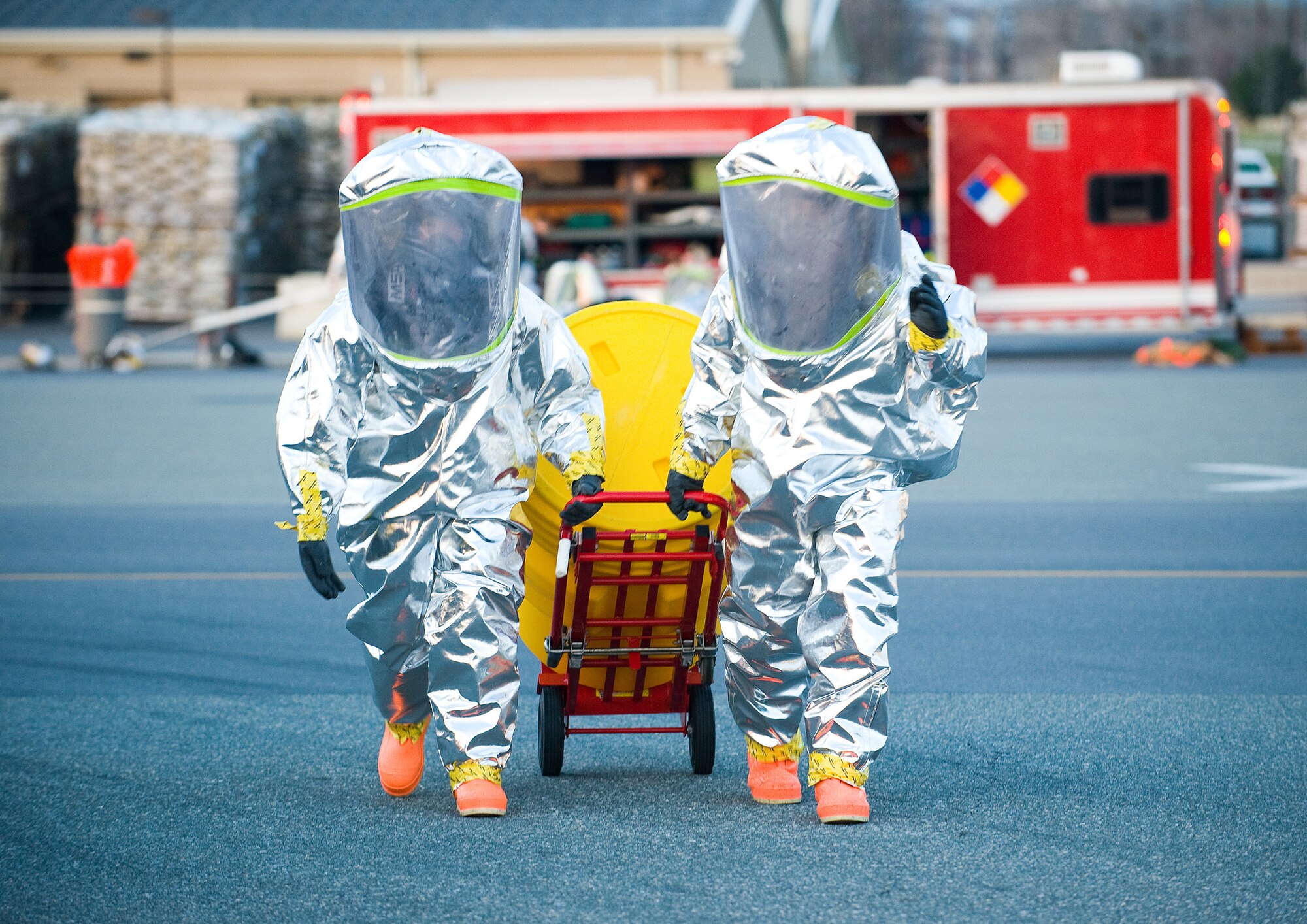 Two 436th Civil Engineer Squadron firefighters move a hazardous material spill kit during a Major Accident Response Exercise at Dover Air Force Base April 9. The Airmen practiced donning their Flash-Protected Level A suits during the MARE. In the event of a real-world emergency, the flash suits, coupled with other hazardous material gear, would keep them safe from hazardous chemical environments. (U.S. Air Force photo/Tom Randle)